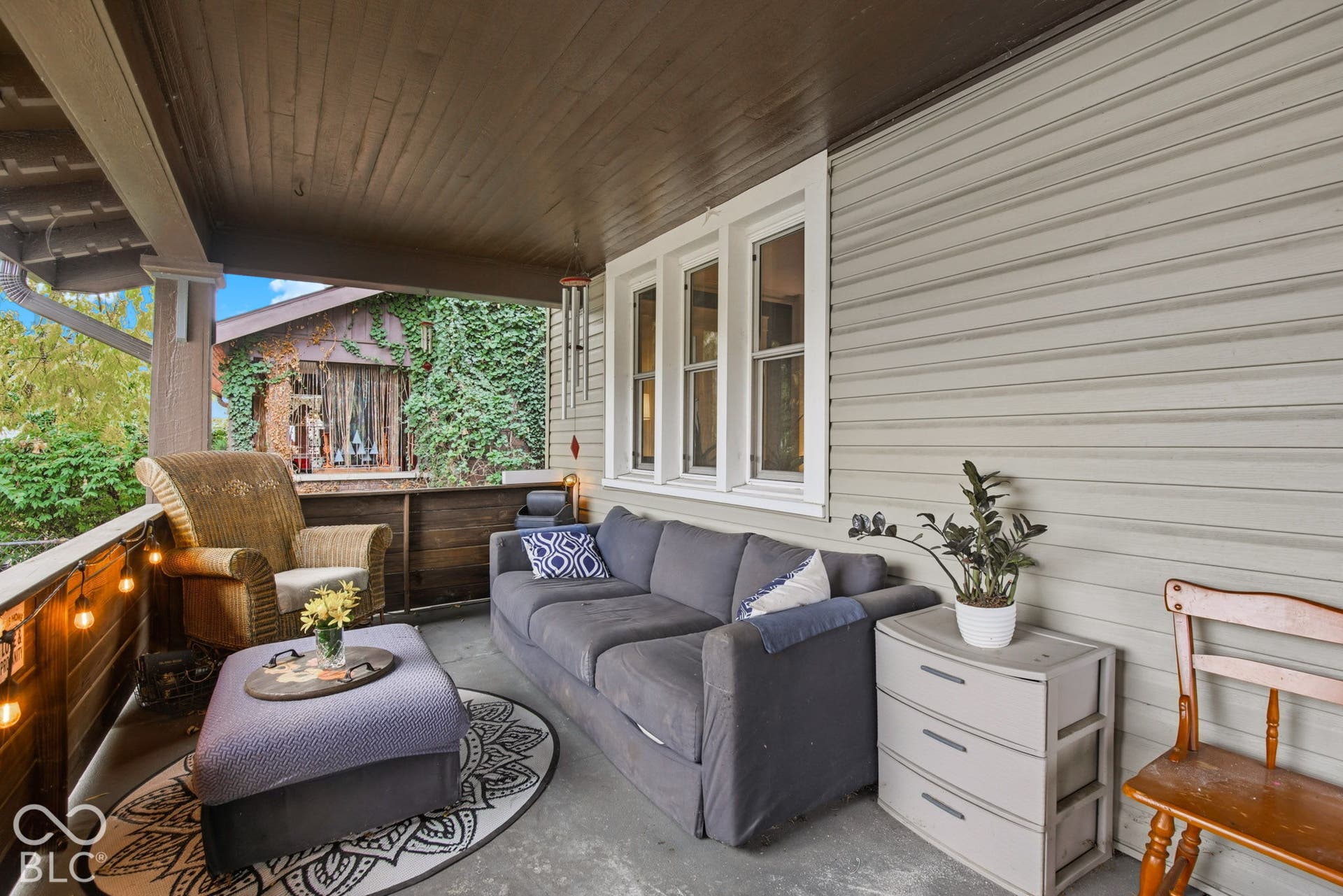 Covered porch featuring wood-paneled ceiling, lap siding, and white-trimmed windows