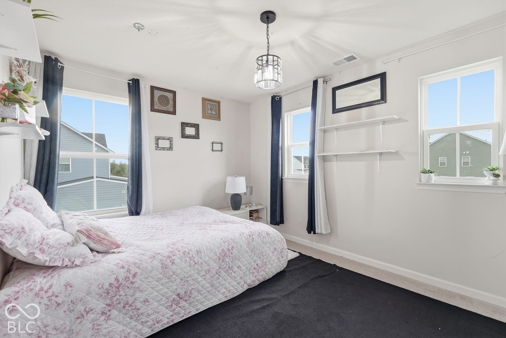 275 Bohicket Road, Whiteland, IN 46184 Neutral-toned interior featuring three double-hung windows, built-in wall shelving, and a decorative industrial-style pendant light