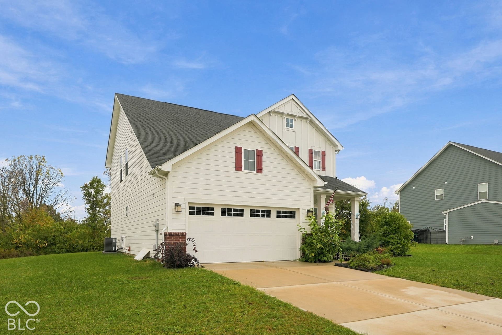 275 Bohicket Road, Whiteland, IN 46184 Two-story residence featuring light-colored horizontal siding, decorative red shutters, an attached two-car garage with transom windows, and a concrete driveway