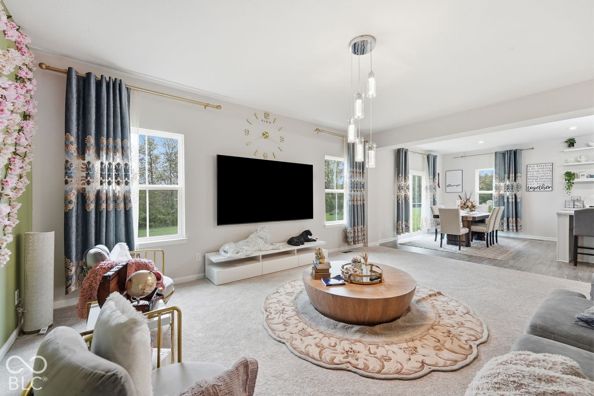 275 Bohicket Road, Whiteland, IN 46184 Open-concept living space featuring high ceilings, multi-pendant contemporary lighting, neutral carpeting, and large windows with natural light