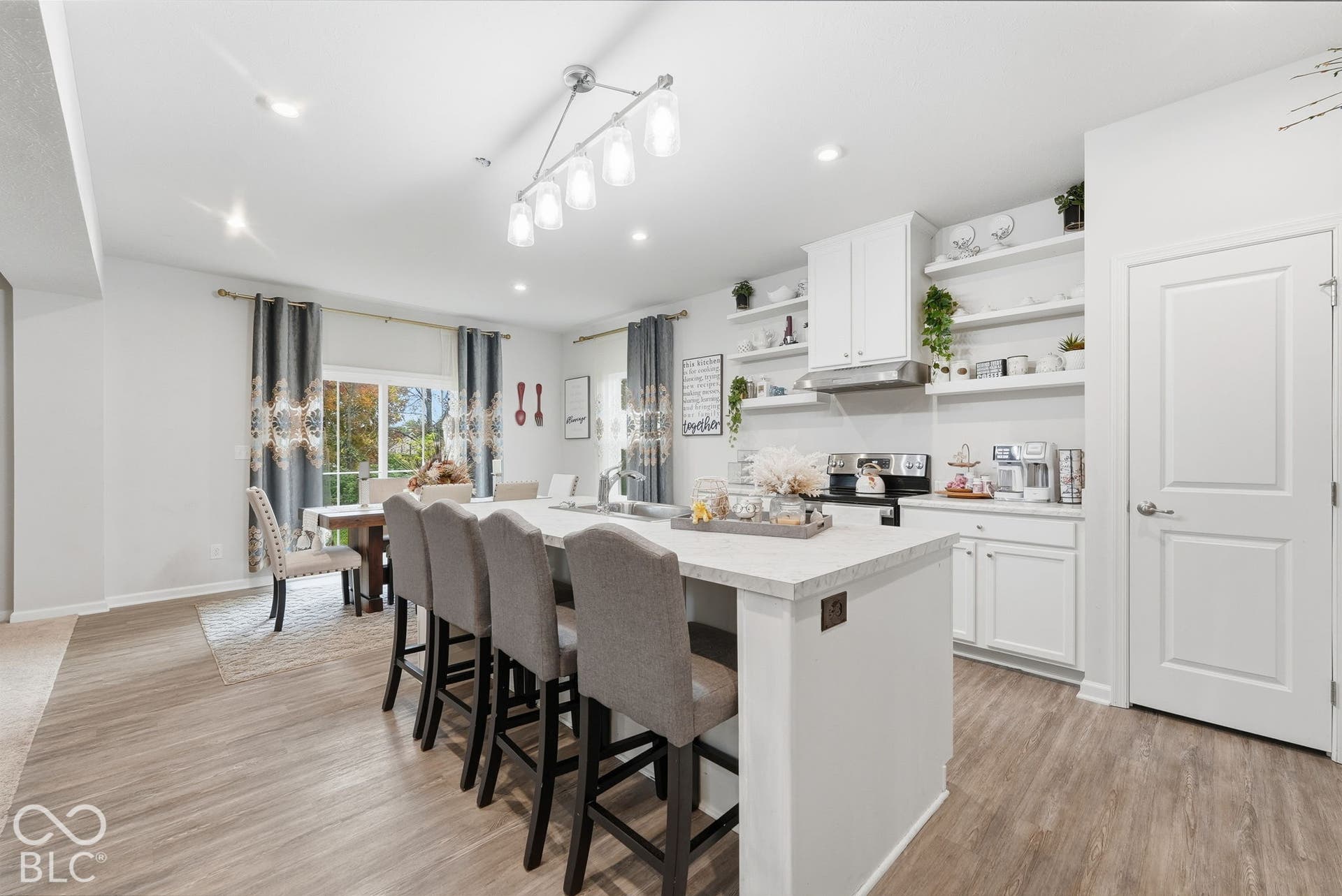 275 Bohicket Road, Whiteland, IN 46184 Kitchen featuring a central island with a stone-finish countertop, white shaker-style cabinetry, open shelving, stainless steel range hood, and wood-finish flooring