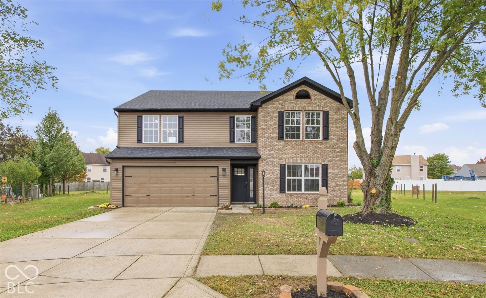 9607 Piper Lake Drive, Indianapolis, IN 46239 Two-story exterior featuring a brick and horizontal siding facade, asphalt shingle roof, attached two-car garage, and concrete driveway