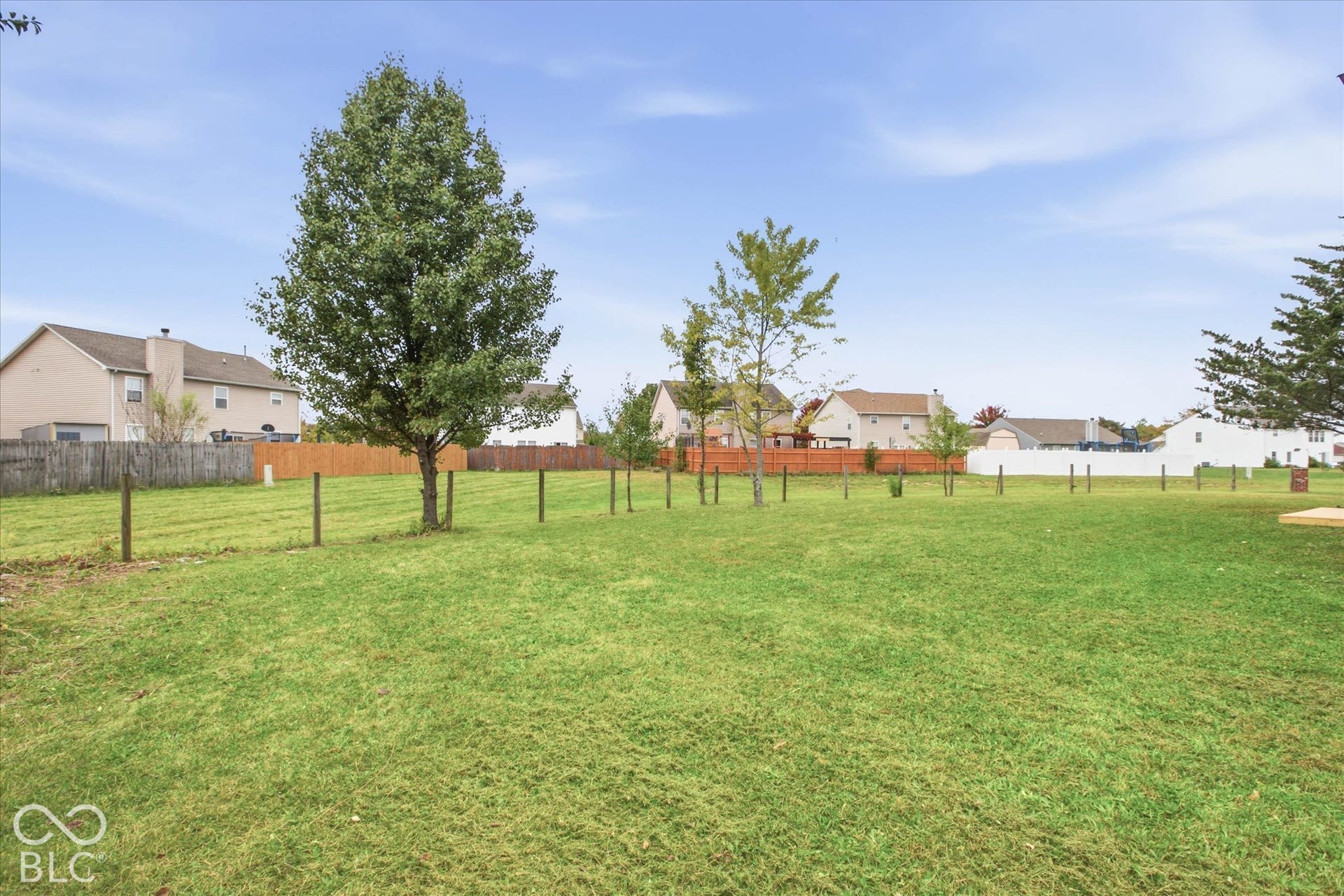 9607 Piper Lake Drive, Indianapolis, IN 46239 Expansive backyard featuring a level lawn, mature trees, and perimeter fencing