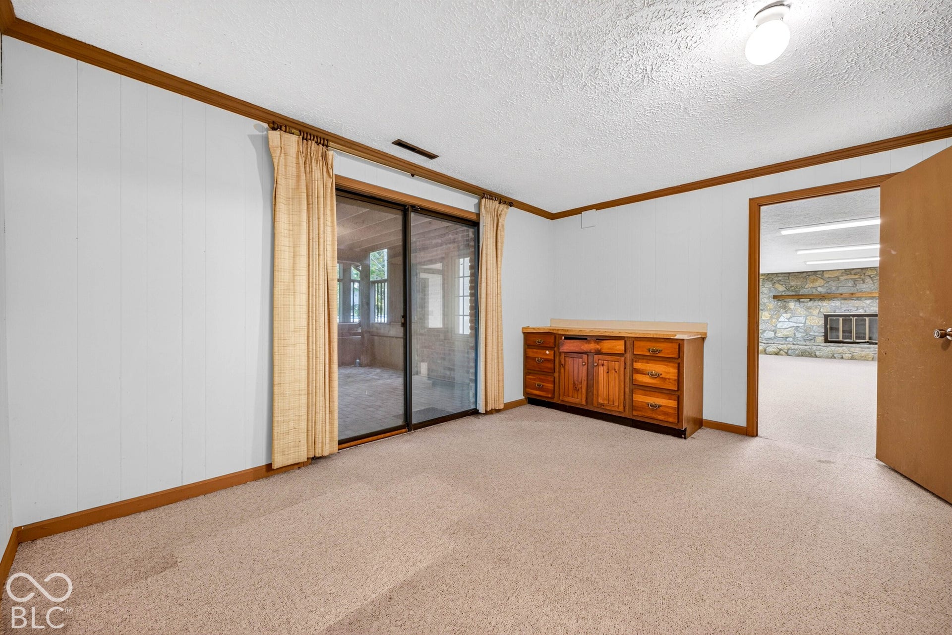 Built-in wood cabinetry, sliding glass doors, and carpeting