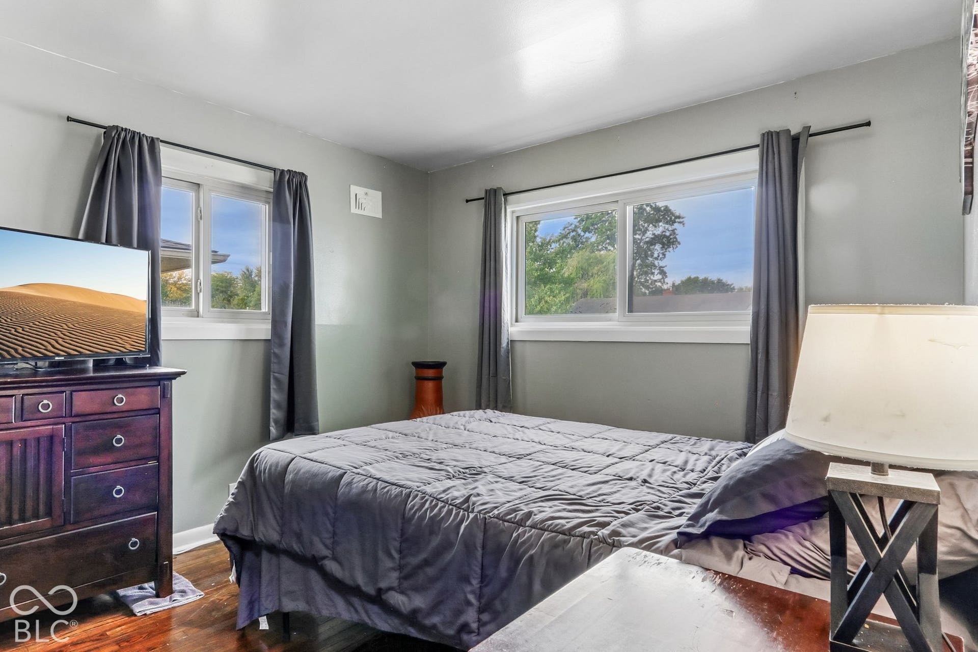 Bedroom featuring wood-finish flooring and dual slider windows
