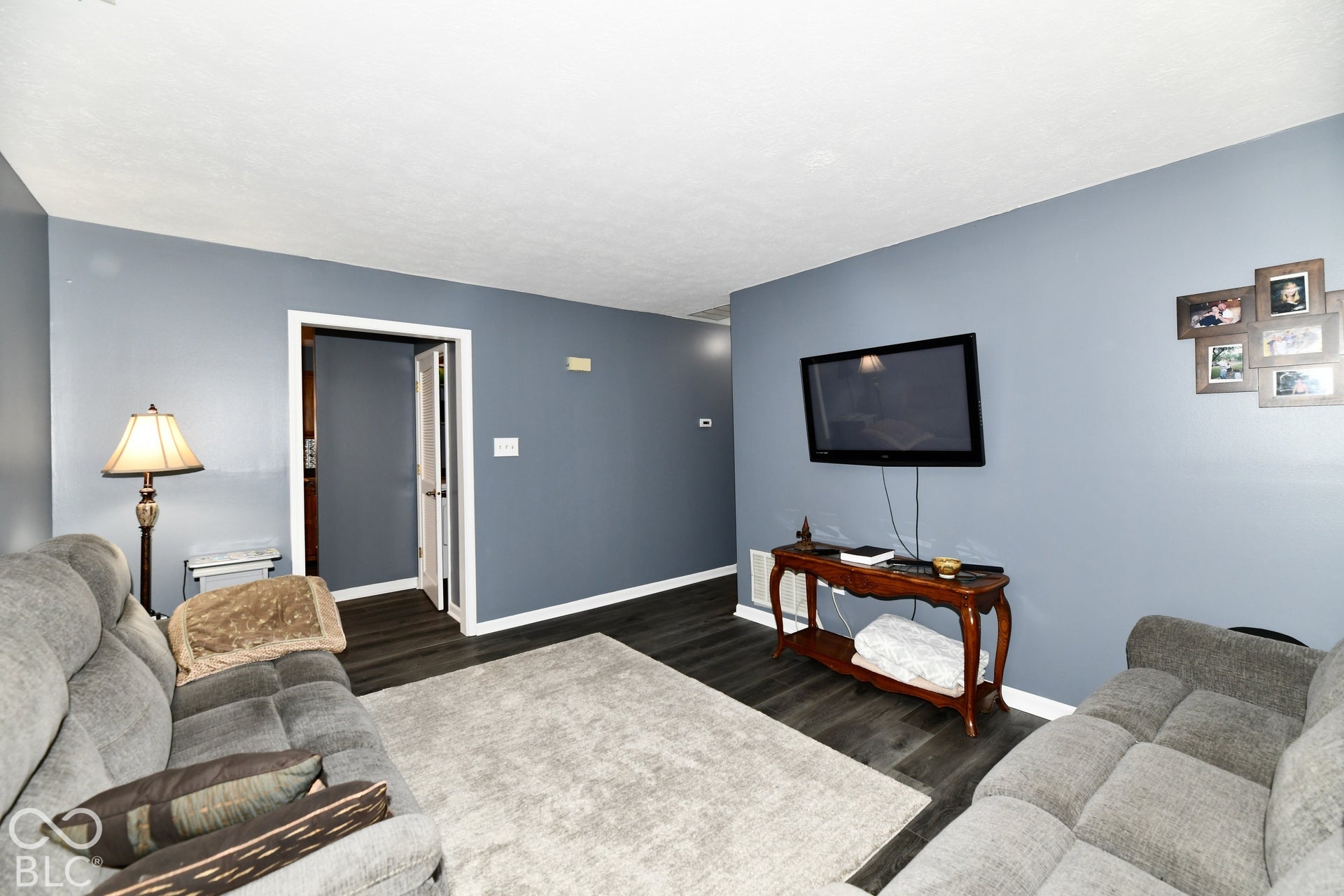 Living room featuring dark-tone wood-finish flooring and neutral wall paint