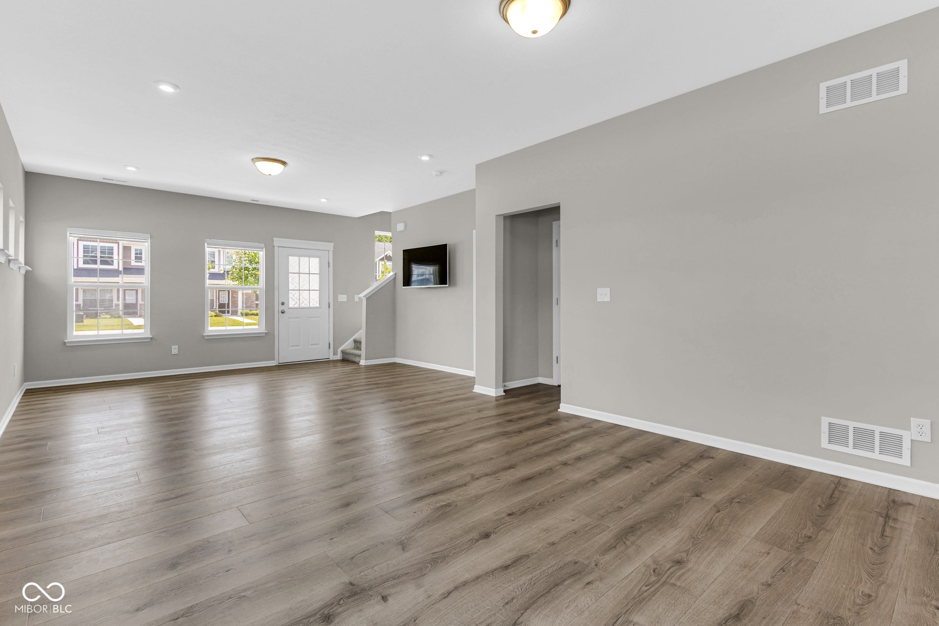 unfurnished living room with stairs, wood finished floors, and recessed lighting