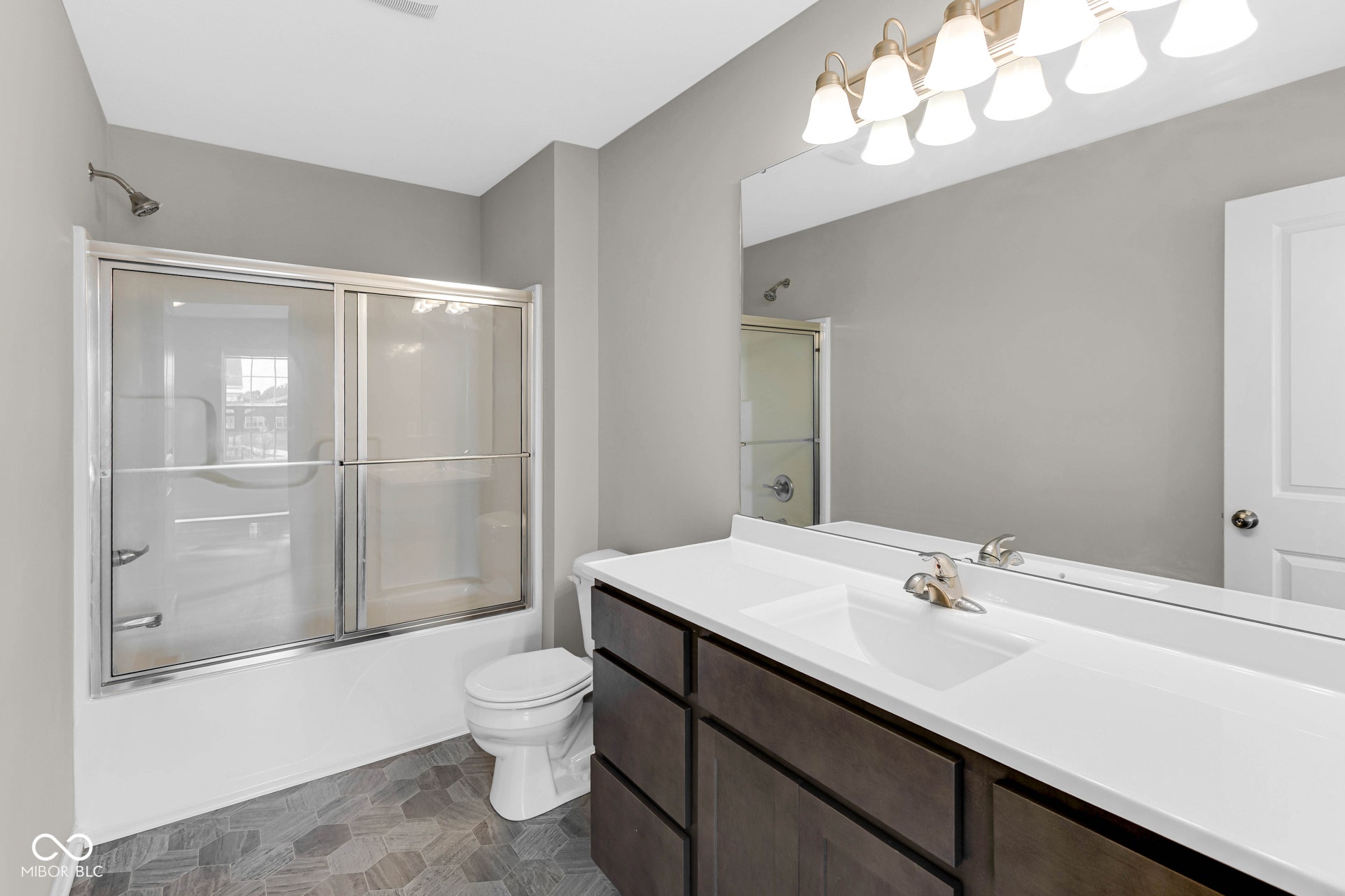 bathroom featuring vanity and shower / bath combination with glass door