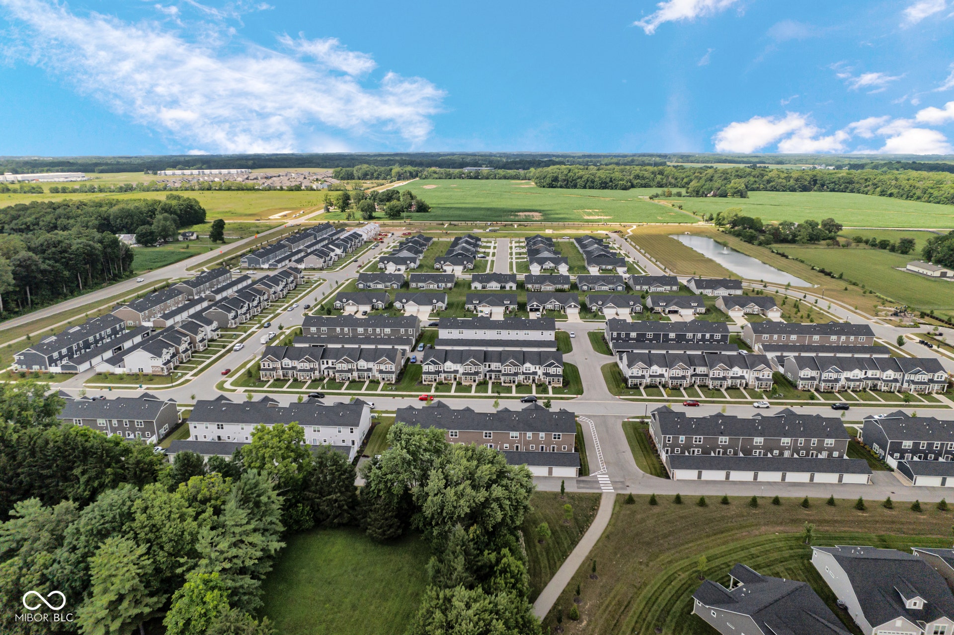 aerial perspective of suburban area featuring a tree filled landscape