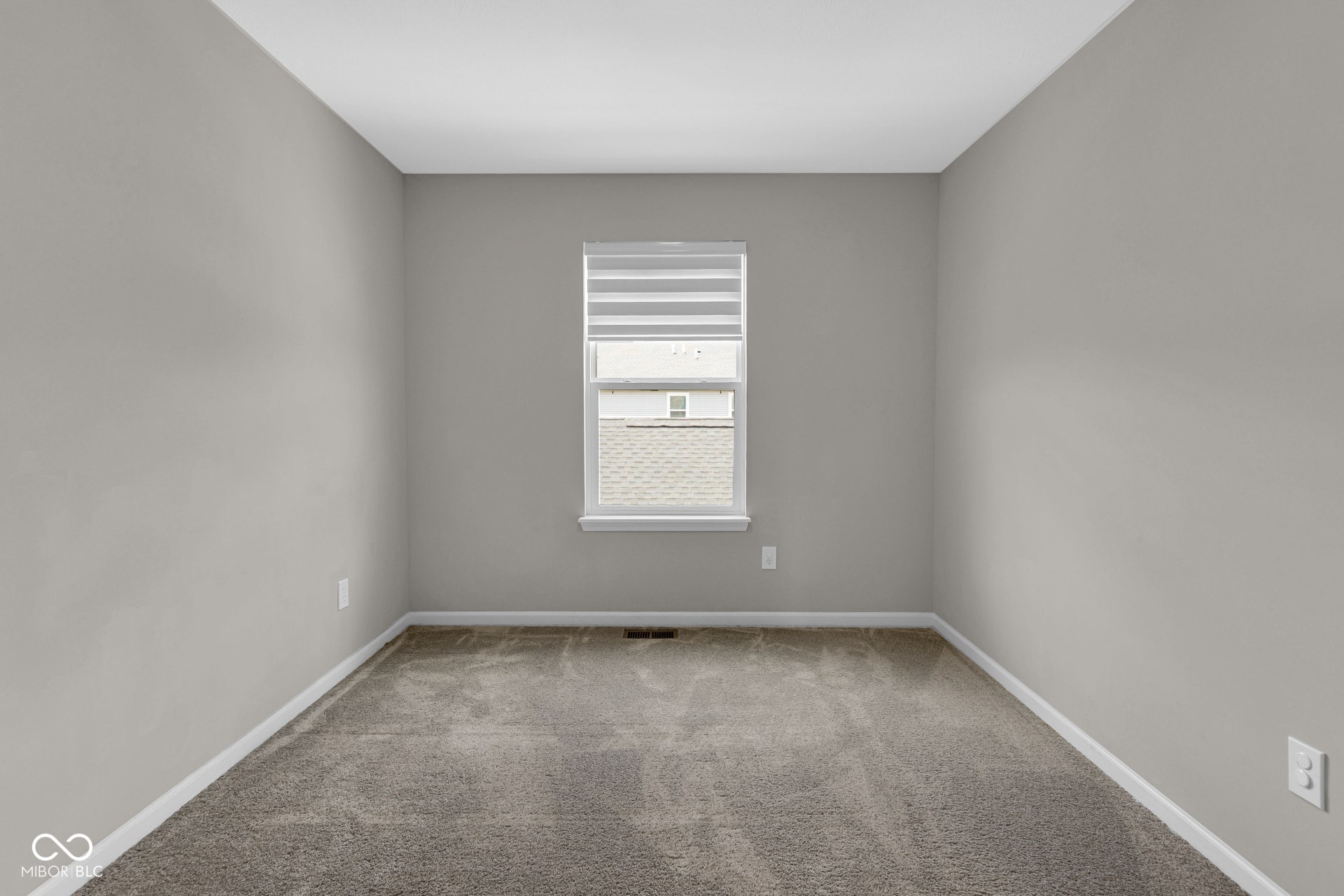carpeted spare room featuring baseboards