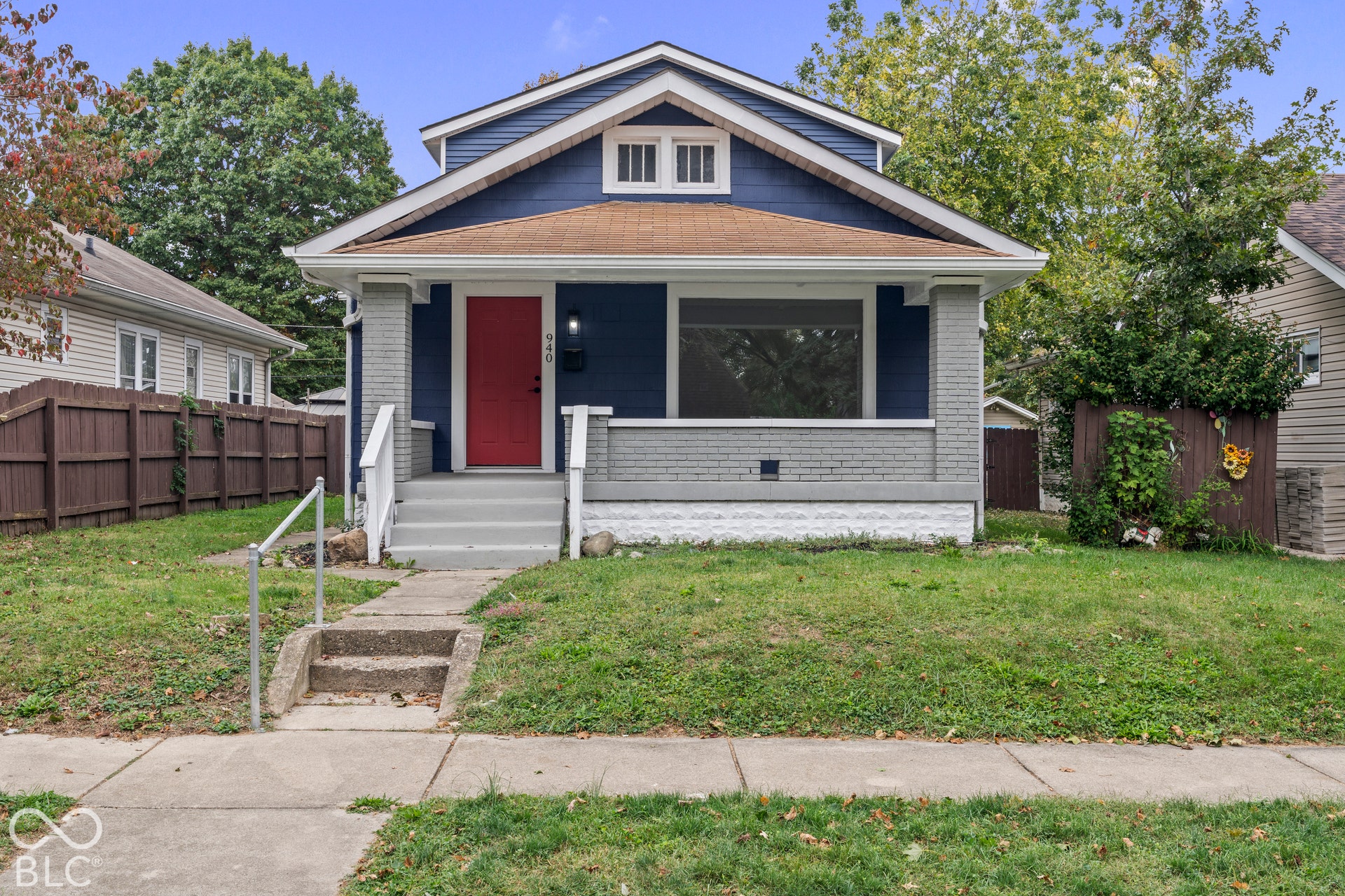 Craftsman-style exterior featuring lap siding, a front porch with brick pillars, and a concrete walkway