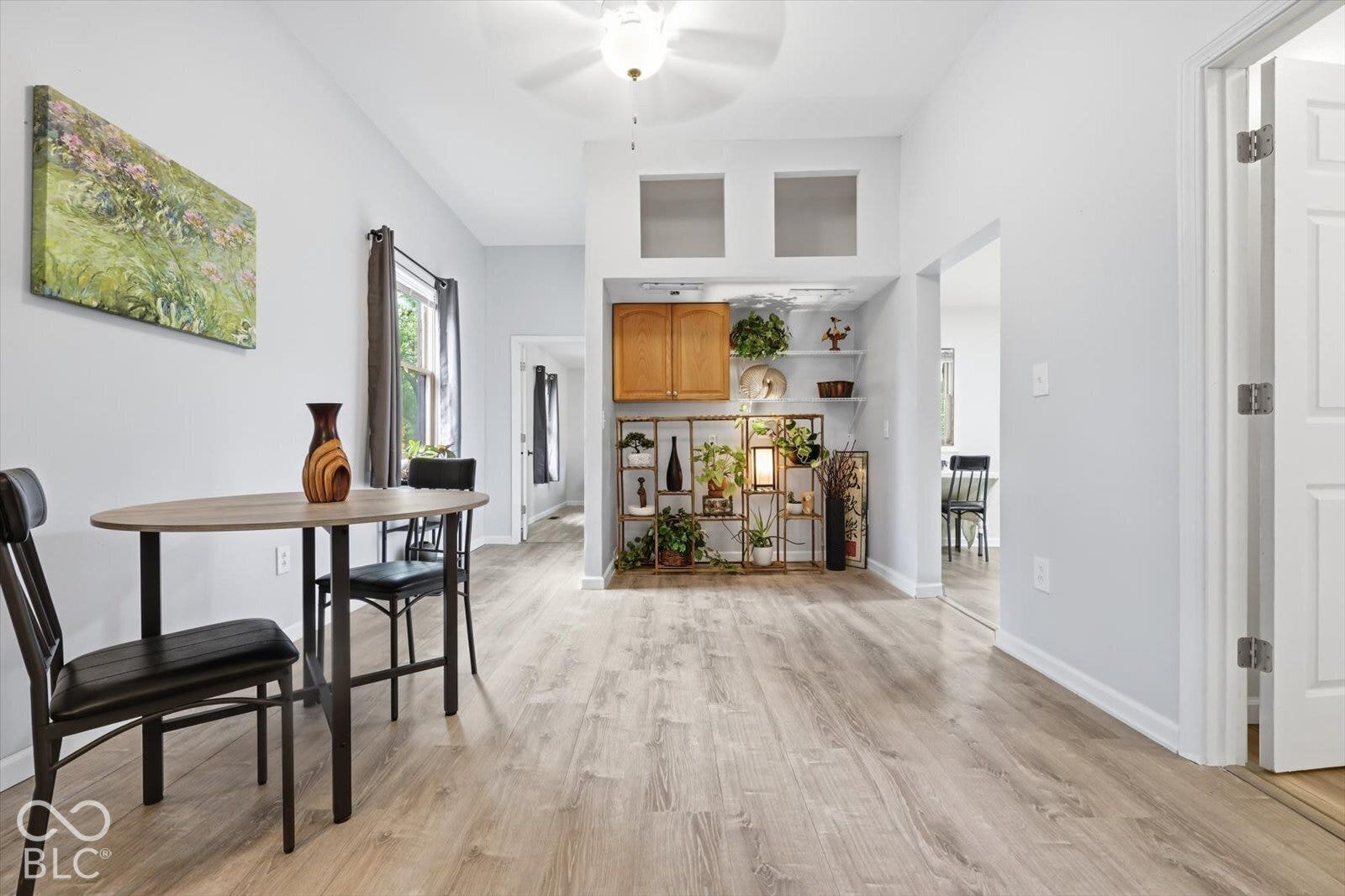 Wood-finish flooring, built-in recessed cabinetry, and a ceiling fan fixture