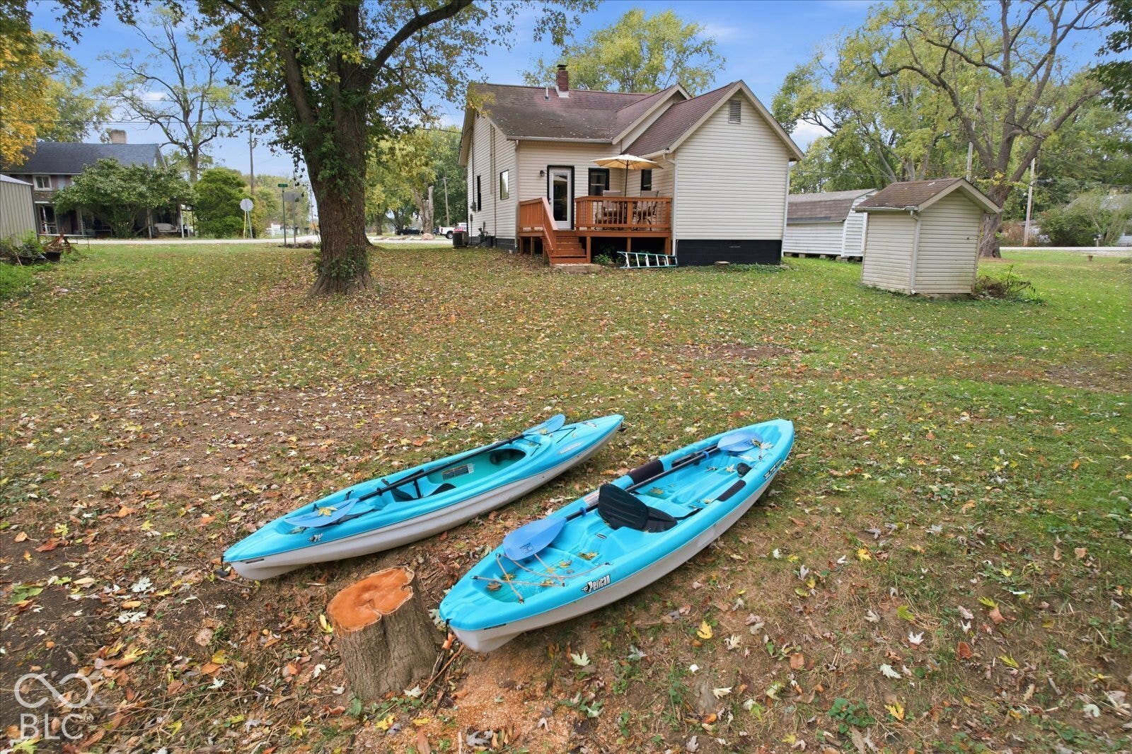 Expansive grounds featuring a wood deck, mature trees, and a detached structure