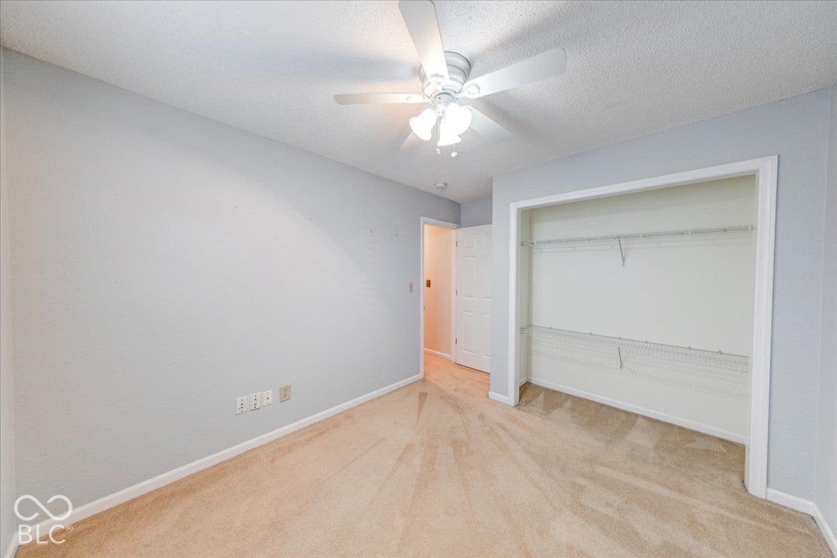 6405 Lonestar Drive, Indianapolis, IN 46237 Room featuring neutral-toned carpeting, a ceiling-mounted light fixture with a fan, and a closet with installed wire shelving