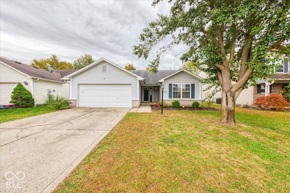 6405 Lonestar Drive, Indianapolis, IN 46237 Ranch-style exterior featuring horizontal siding, brick facade accents, a two-car attached garage, and a concrete driveway