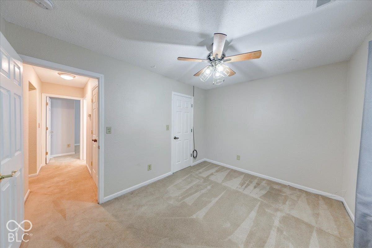 6405 Lonestar Drive, Indianapolis, IN 46237 Neutral-toned room featuring neutral carpeting, a ceiling fan with integrated lighting, and six-panel interior doors