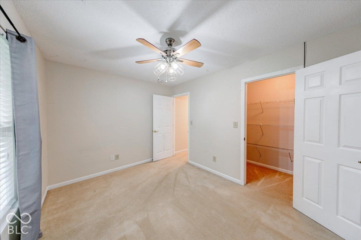 6405 Lonestar Drive, Indianapolis, IN 46237 Neutral interior space featuring carpeting, a ceiling fan with integrated lighting, and a closet with wire shelving