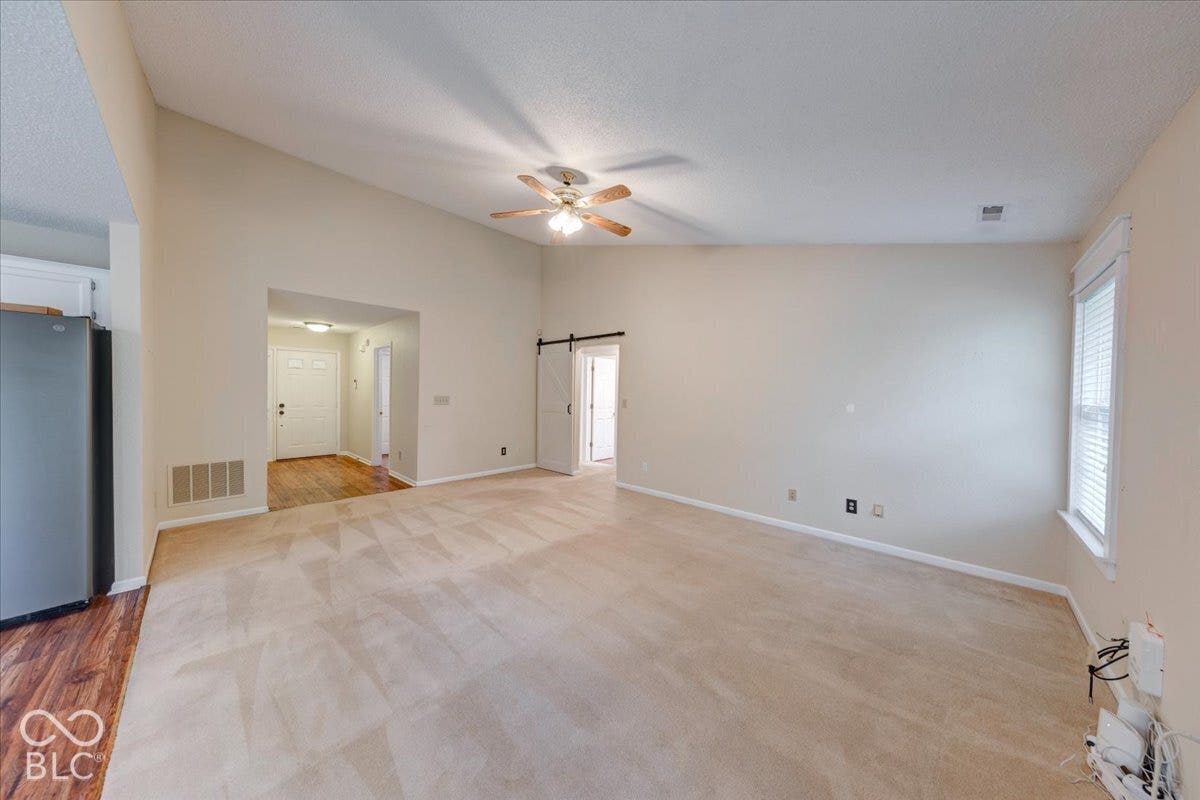 6405 Lonestar Drive, Indianapolis, IN 46237 Vaulted ceilings, sliding barn door, ceiling fan, and window with blinds