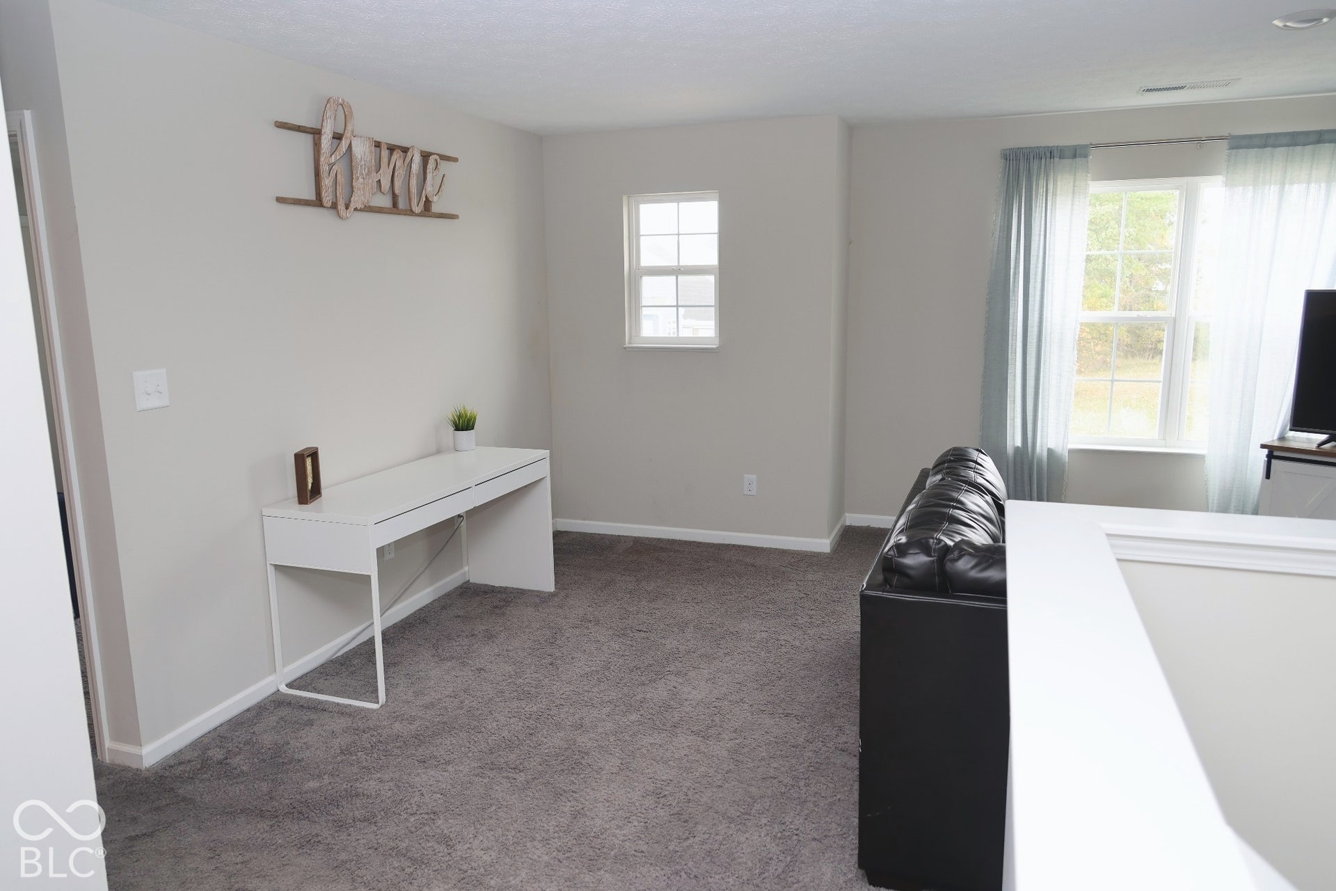 Neutral wall palette featuring carpeted flooring, multiple windows with grid detailing, and recessed ceiling lighting