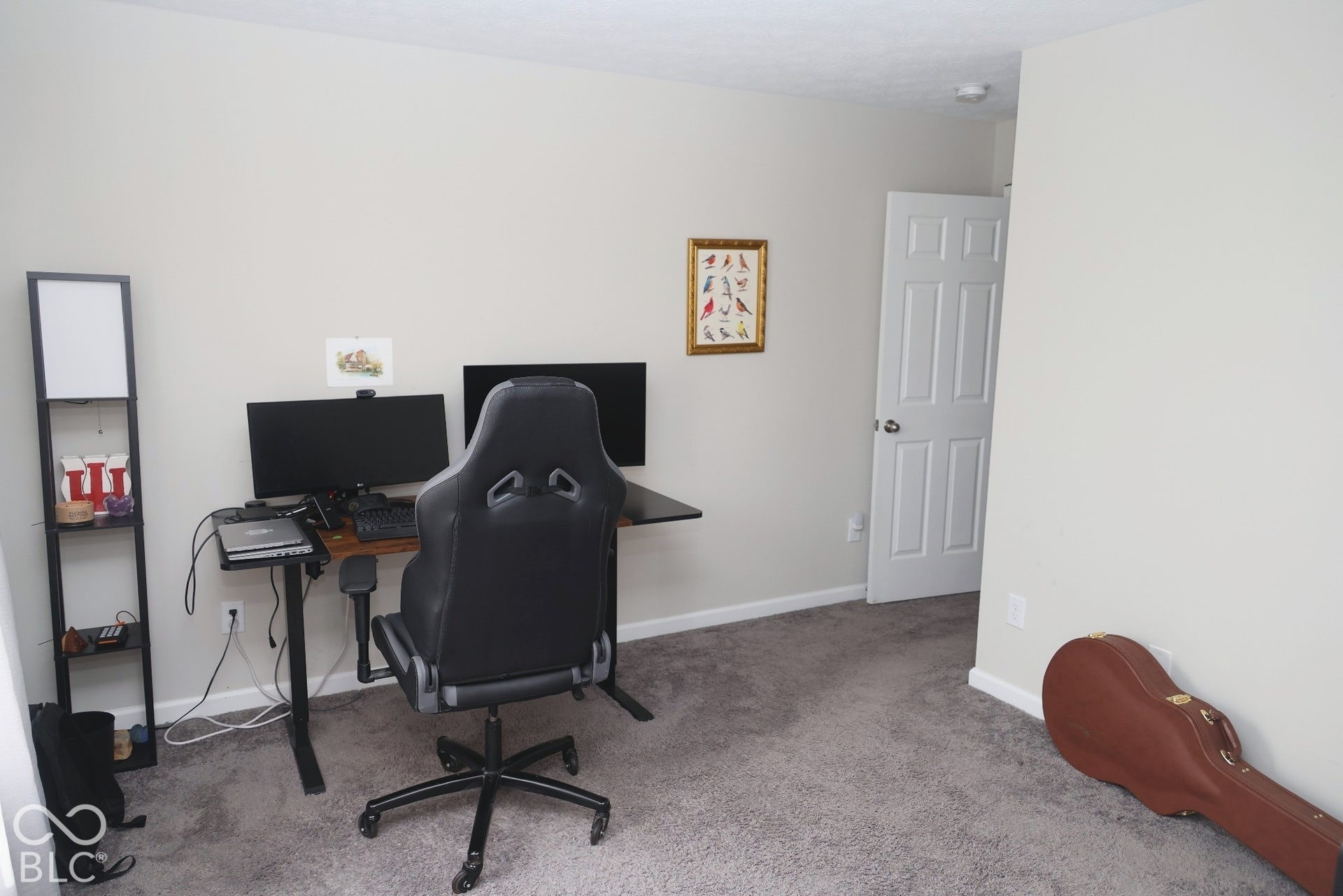 Neutral interior room featuring plush carpeting, a six-panel door, and smooth-finish walls