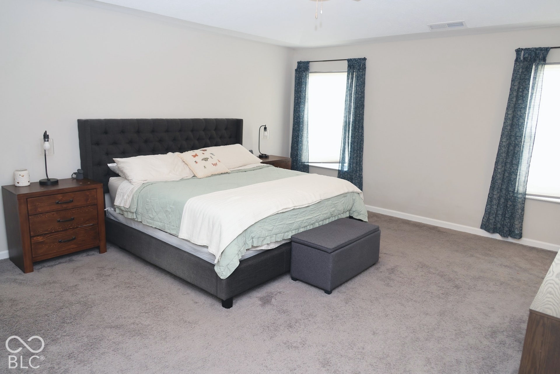 Spacious room featuring neutral wall paint, carpeting, and multiple windows