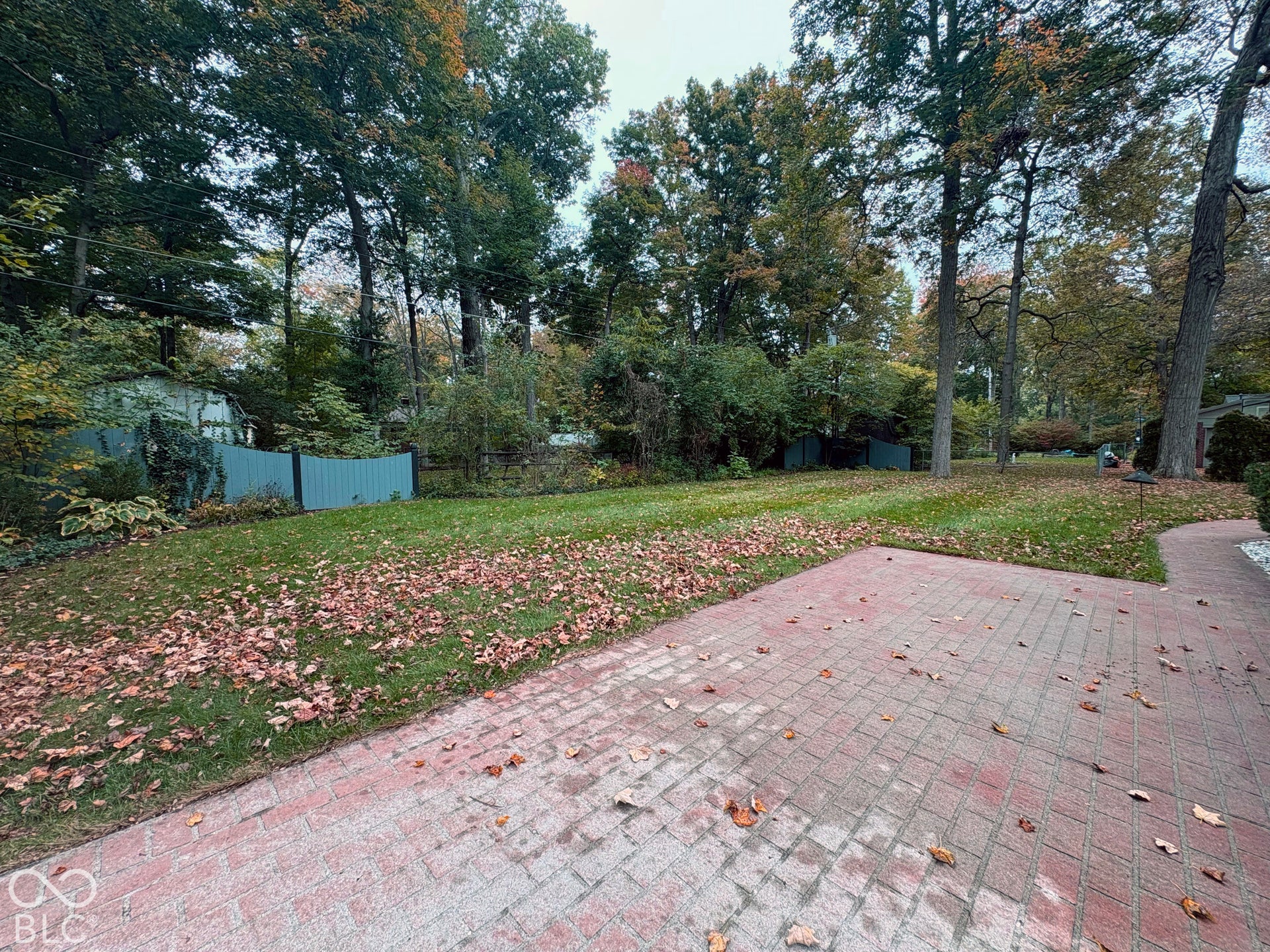 Private back patio and yard with mature trees and gardens.