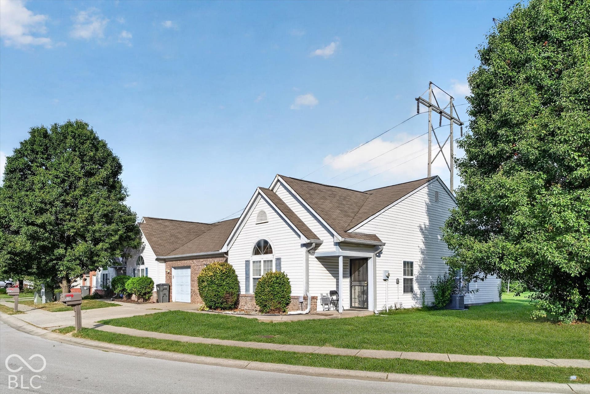 Single-story residence featuring a vinyl siding exterior, an attached one-car garage, brick facade accents, and an arched window design