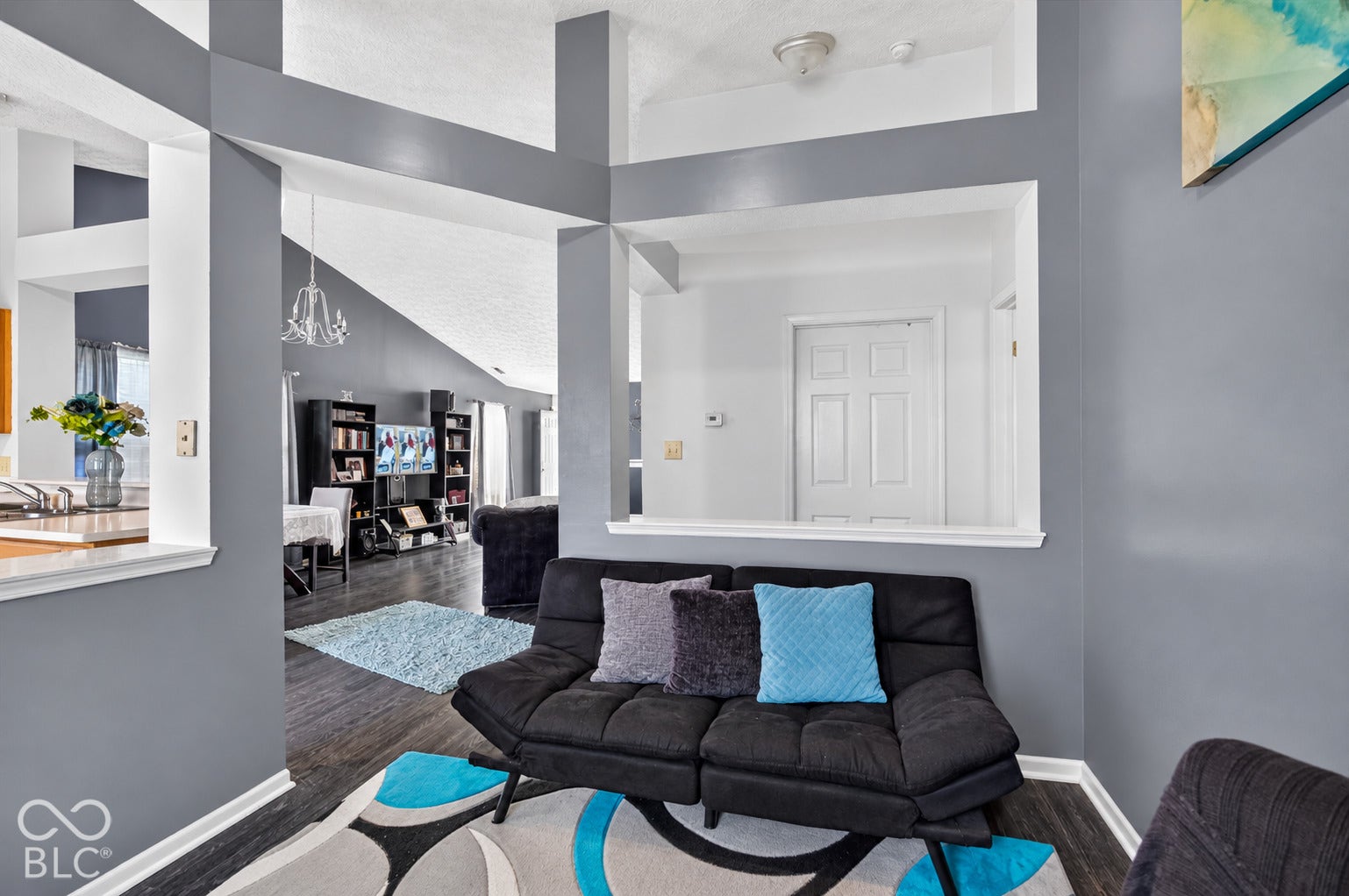 Vaulted ceilings, architectural pass-through wall cutout, and wood-finish flooring