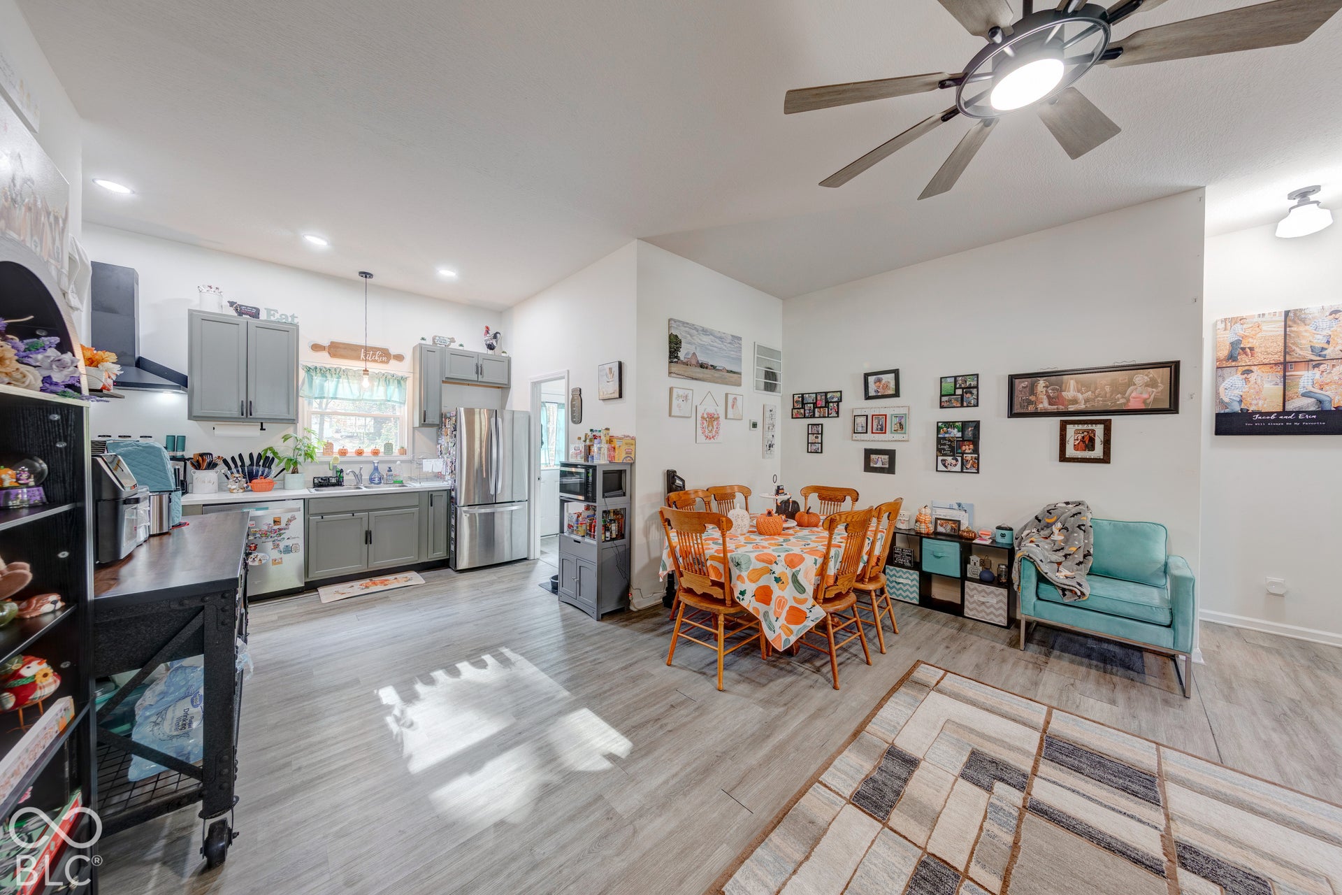 Kitchen featuring grey shaker-style cabinetry, stainless steel appliances, wood-finish flooring, recessed lighting, and a multi-blade ceiling fan with integrated lighting