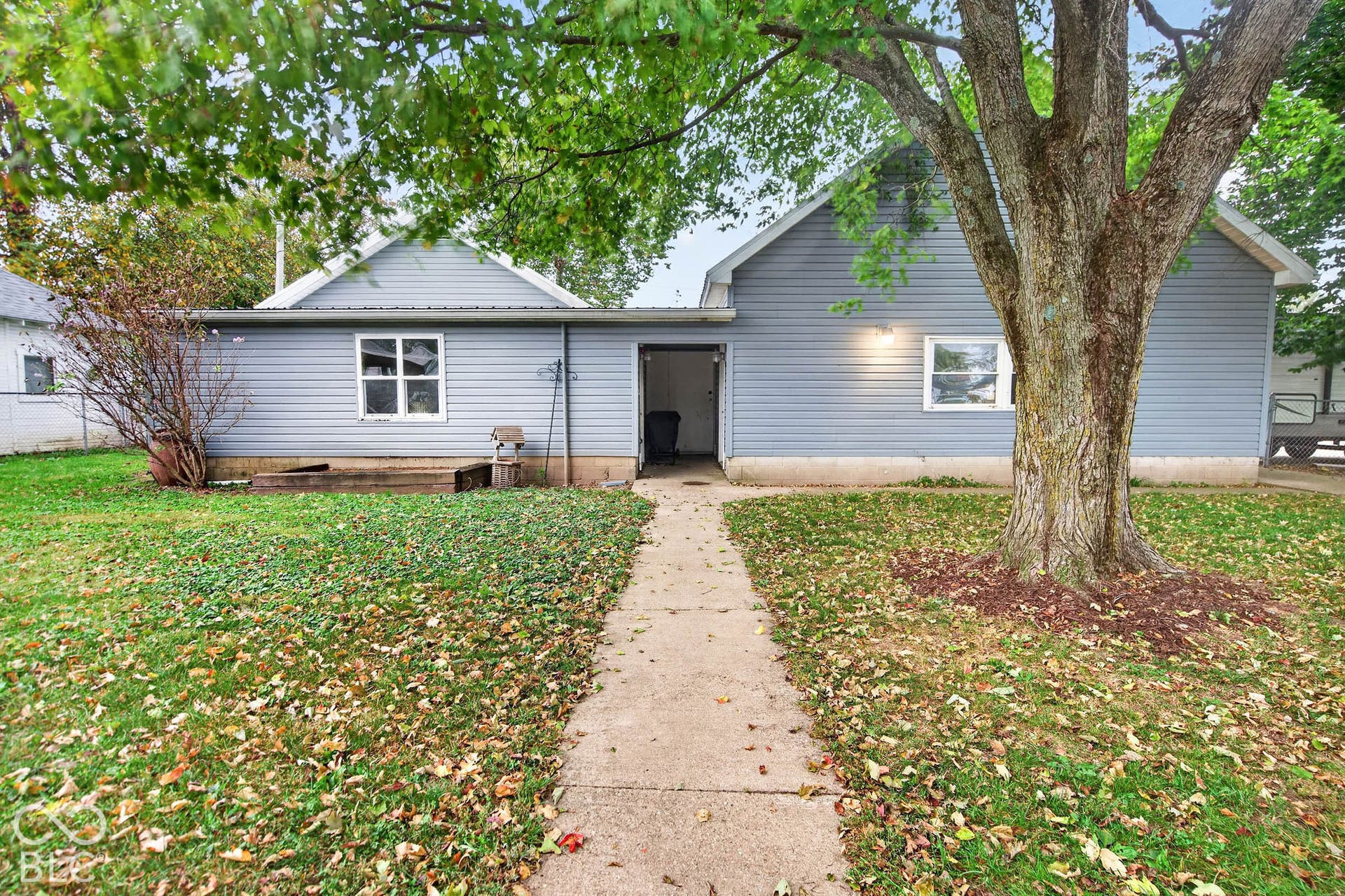 Large detached garage on the right with living quarters or workshop on the left.