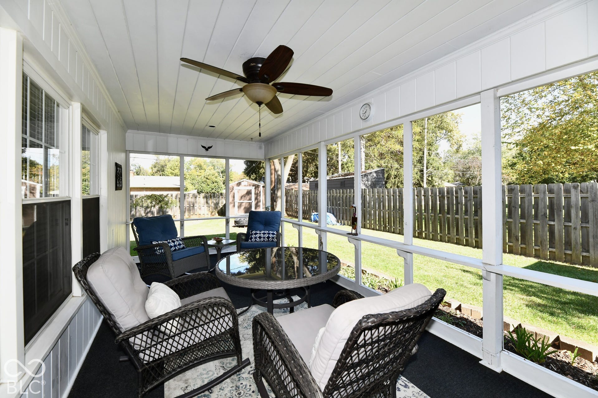Enclosed porch featuring a tongue-and-groove ceiling, ceiling fan, and full-length screens overlooking a fenced backyard