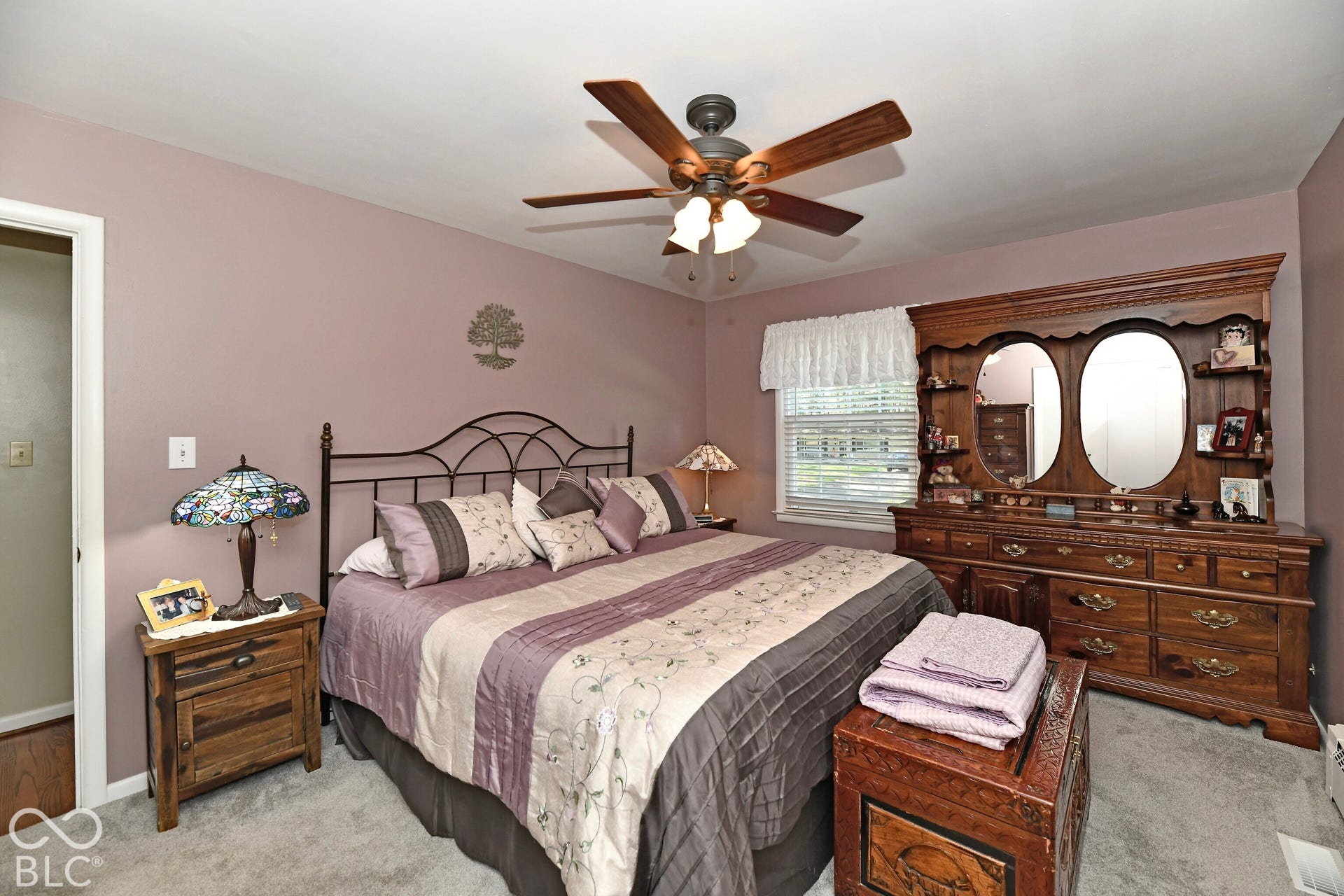 Bedroom featuring wall-to-wall carpeting, a multi-blade ceiling fan with integrated lighting, and a single-pane window with white trim