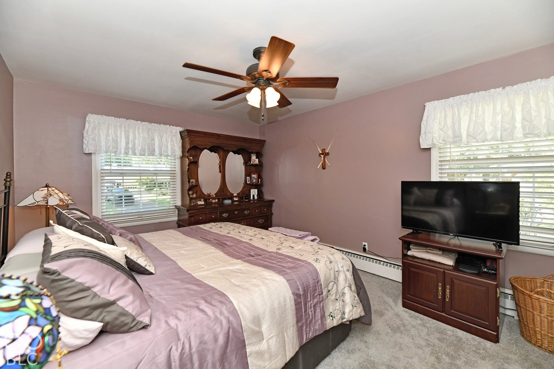 Room featuring wall-to-wall carpeting, dual windows with scalloped valances, and a ceiling fan with integrated light fixture