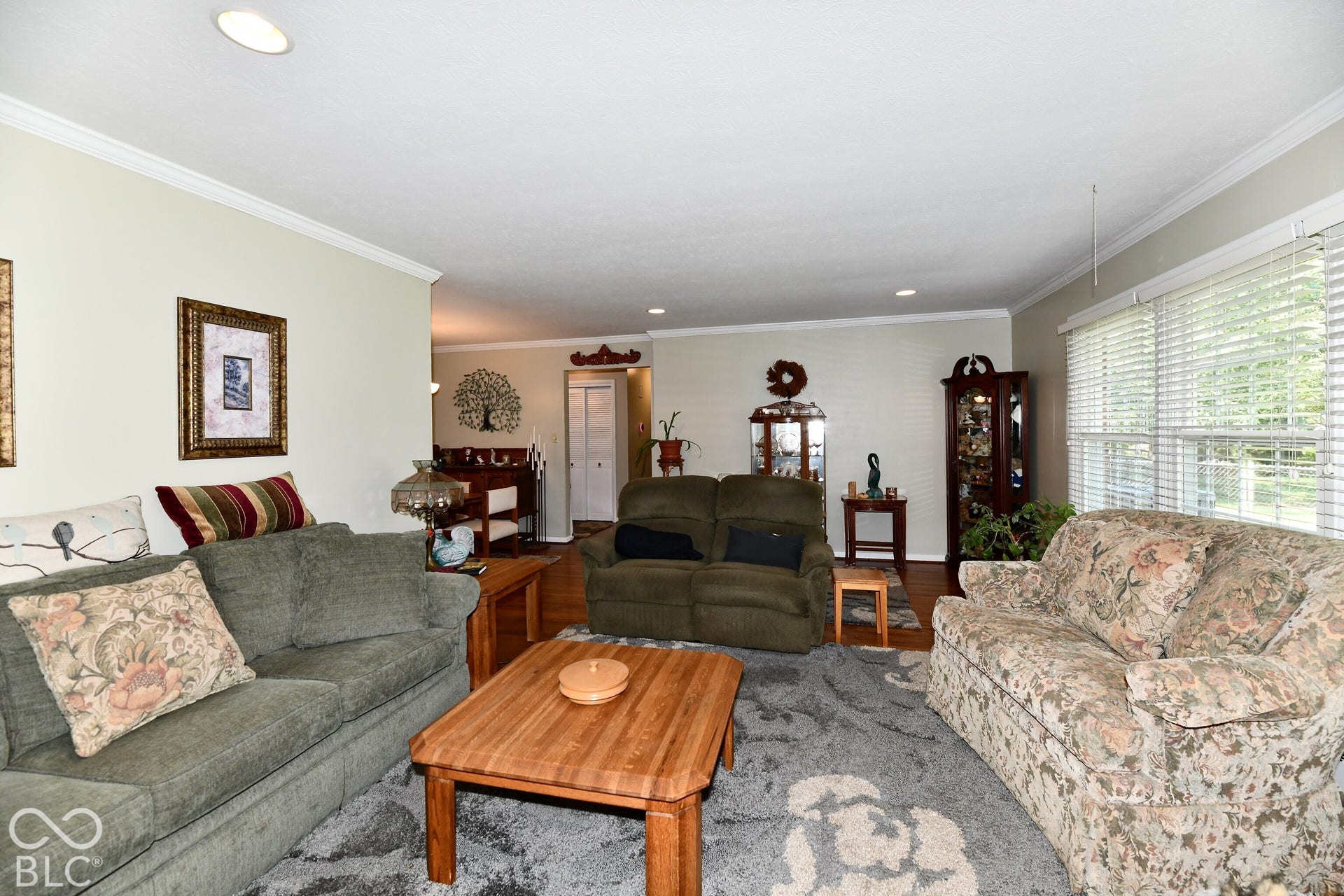Interior space featuring crown molding, recessed lighting, and large windows with horizontal blinds