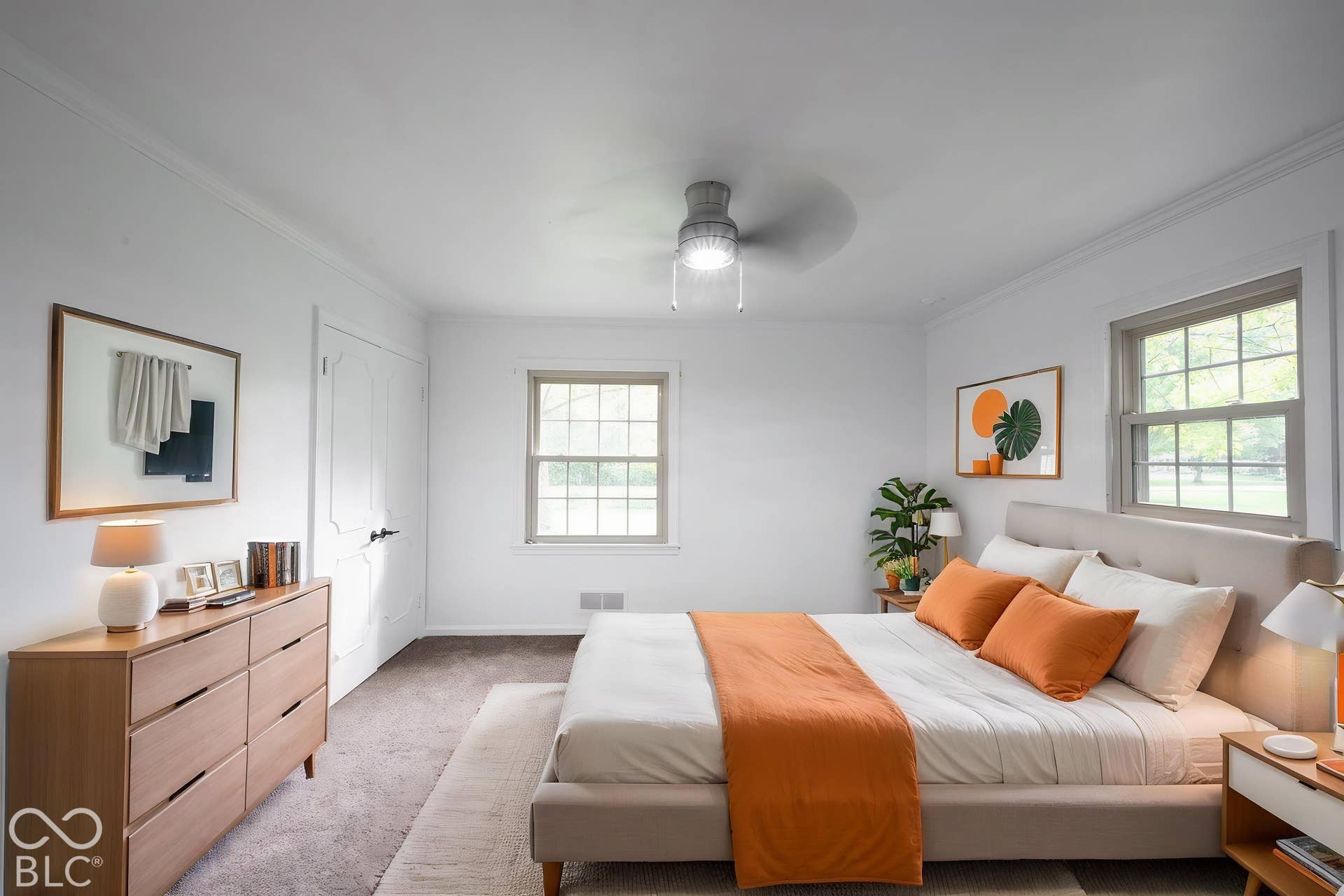 Room featuring neutral carpeting, double-hung windows with exterior trim, and a ceiling-mounted light fixture with fan