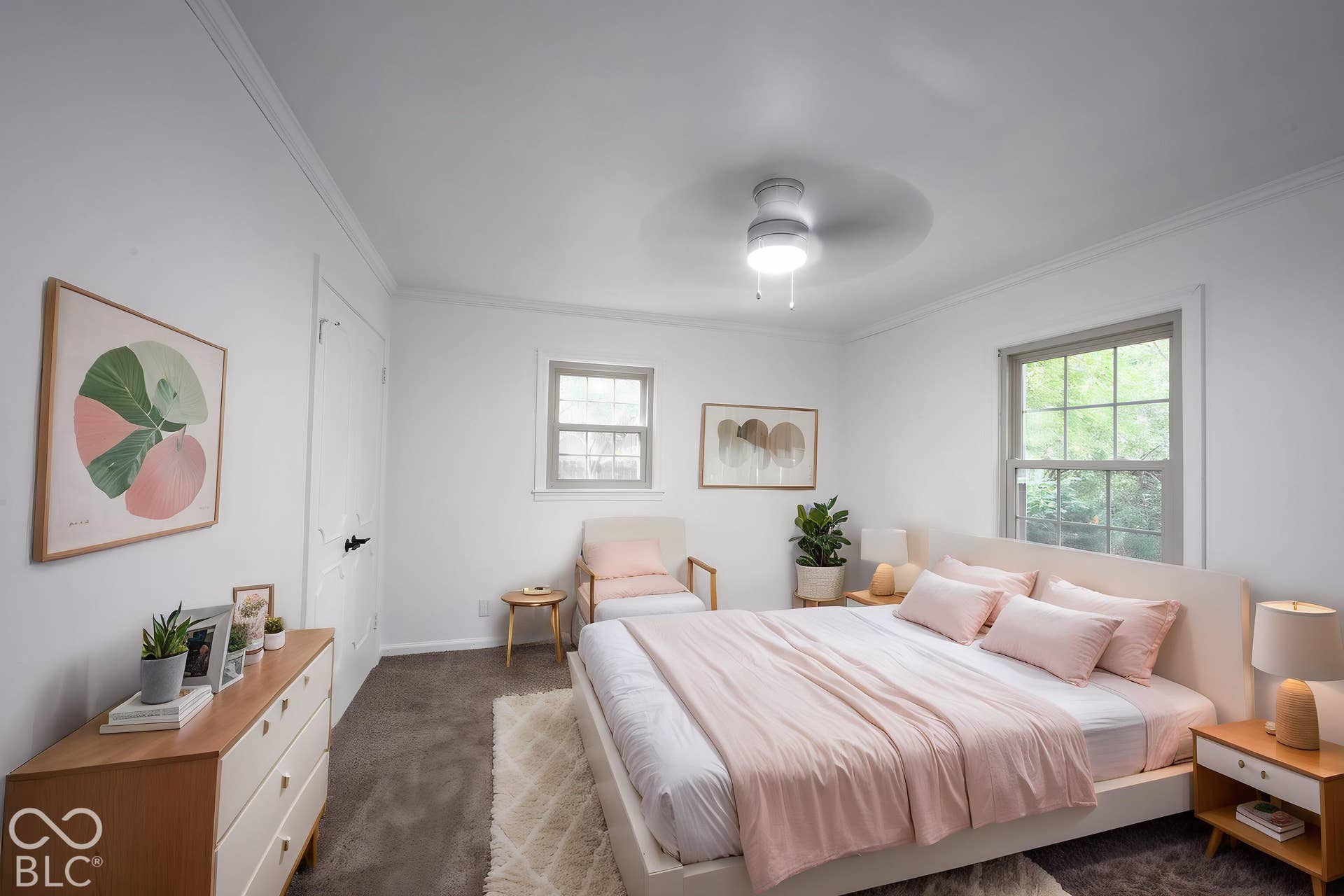 Neutral-toned interior space featuring carpeting, ceiling-mounted lighting with an integrated fan, multi-pane windows with trim, and a door with matte black hardware