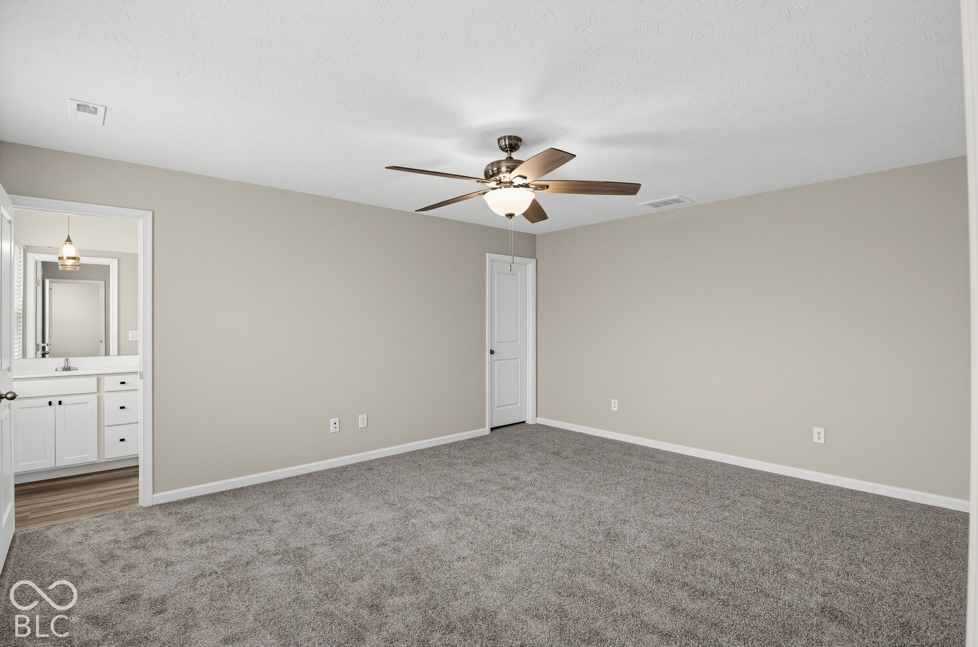 Neutral-toned interior space featuring neutral wall paint, wall-to-wall carpeting, and a ceiling fan with integrated lighting