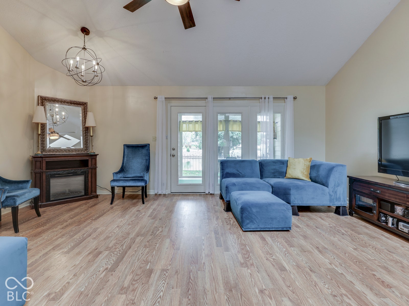 770 Ivy Lane, Greenwood, IN 46143 Vaulted ceilings, wood-finish flooring, built-in electric fireplace with an ornate mantel, and glass-paned exterior door with dual sidelights