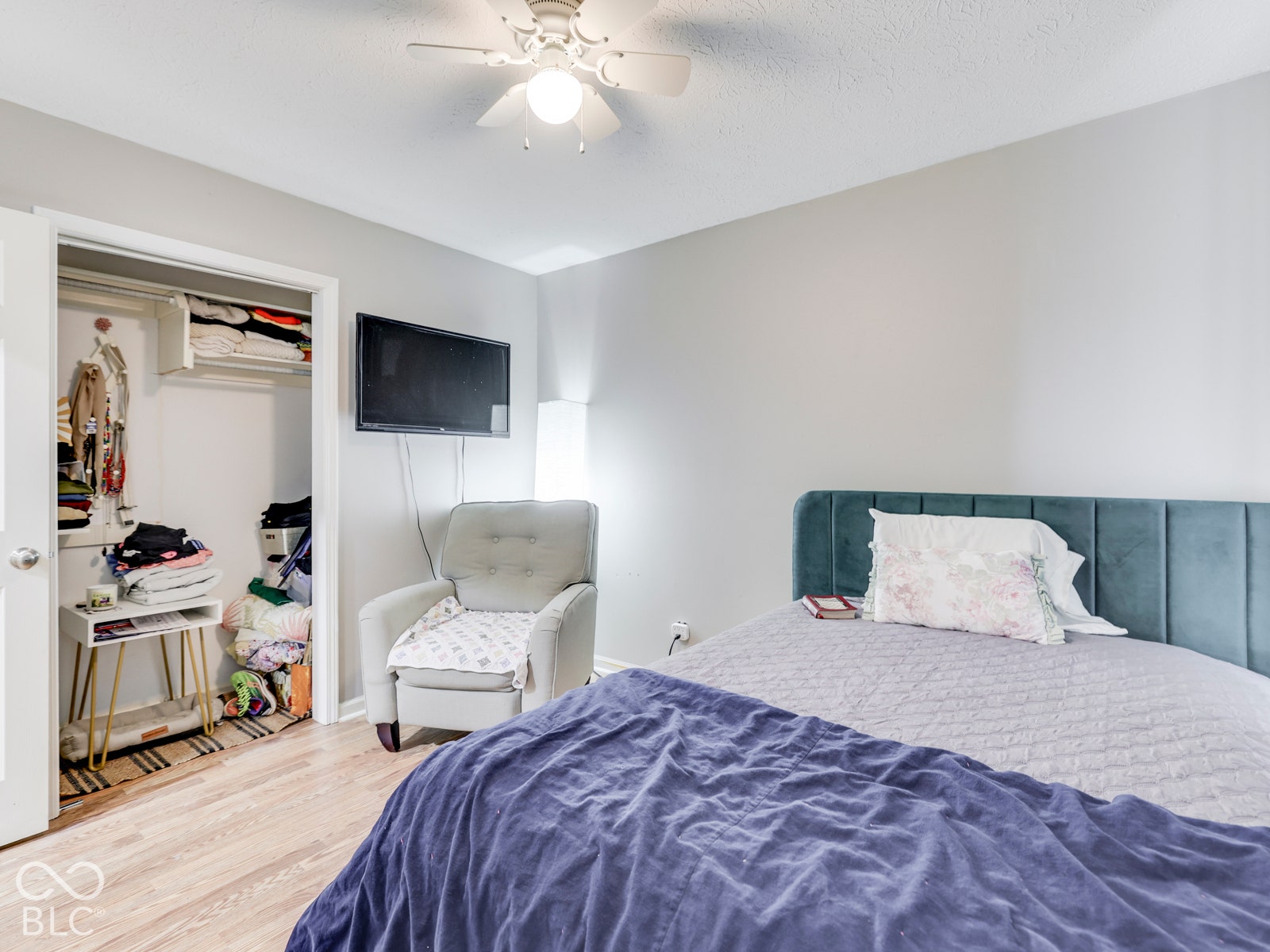 770 Ivy Lane, Greenwood, IN 46143 Neutral wall palette with wood-finish flooring, ceiling fan with integrated lighting, and walk-in closet featuring built-in shelving