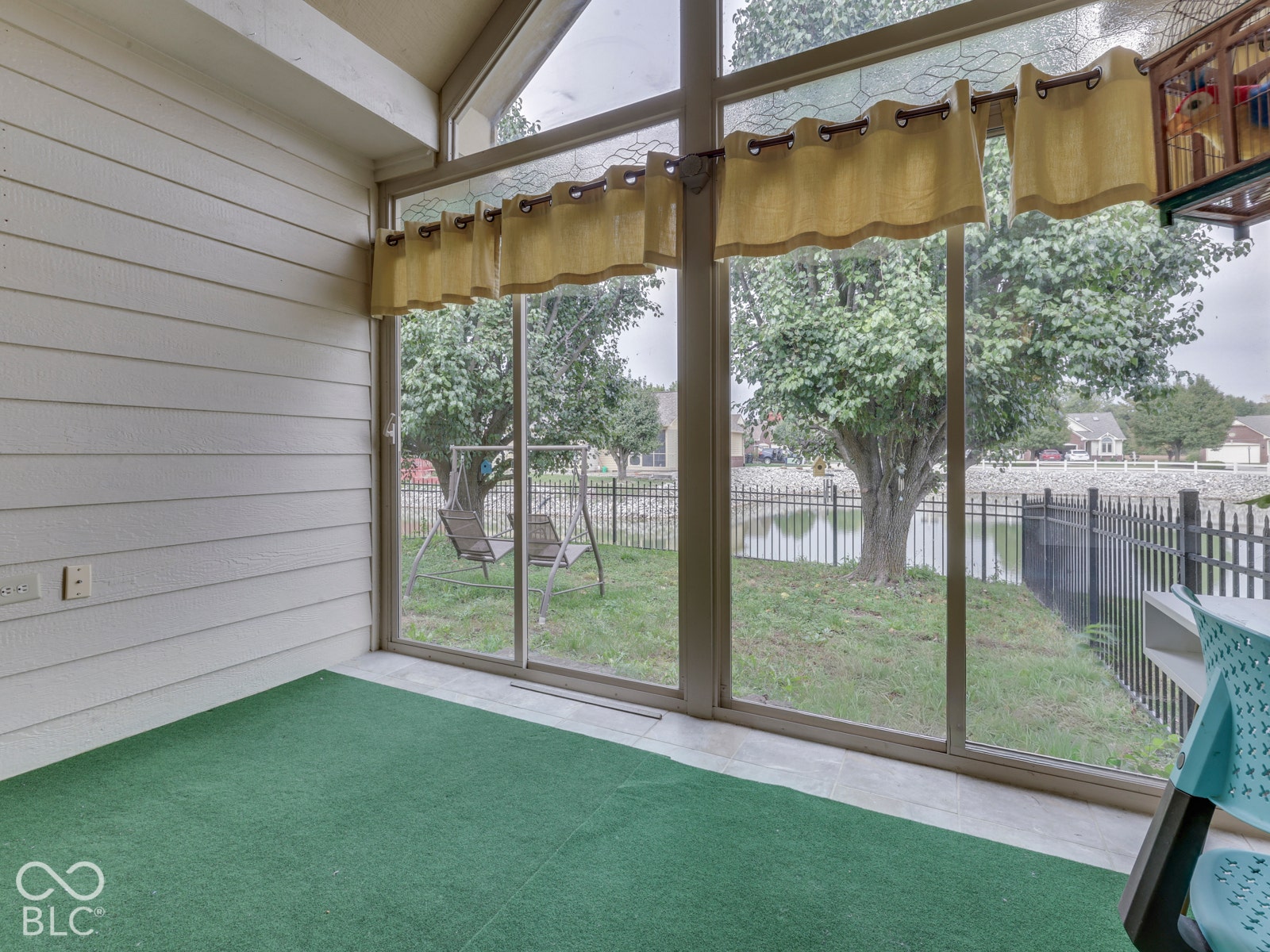 770 Ivy Lane, Greenwood, IN 46143 Sunroom featuring horizontal paneled walls, vaulted ceiling, and expansive floor-to-ceiling glass sliding doors with aluminum framing