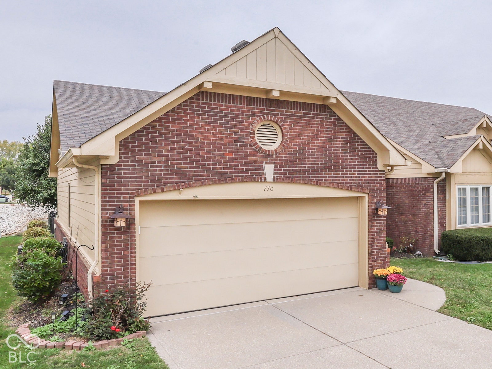 770 Ivy Lane, Greenwood, IN 46143 Brick exterior with horizontal siding gables, asphalt shingle roofing, attached two-car garage with arched header, and decorative circular gable vent