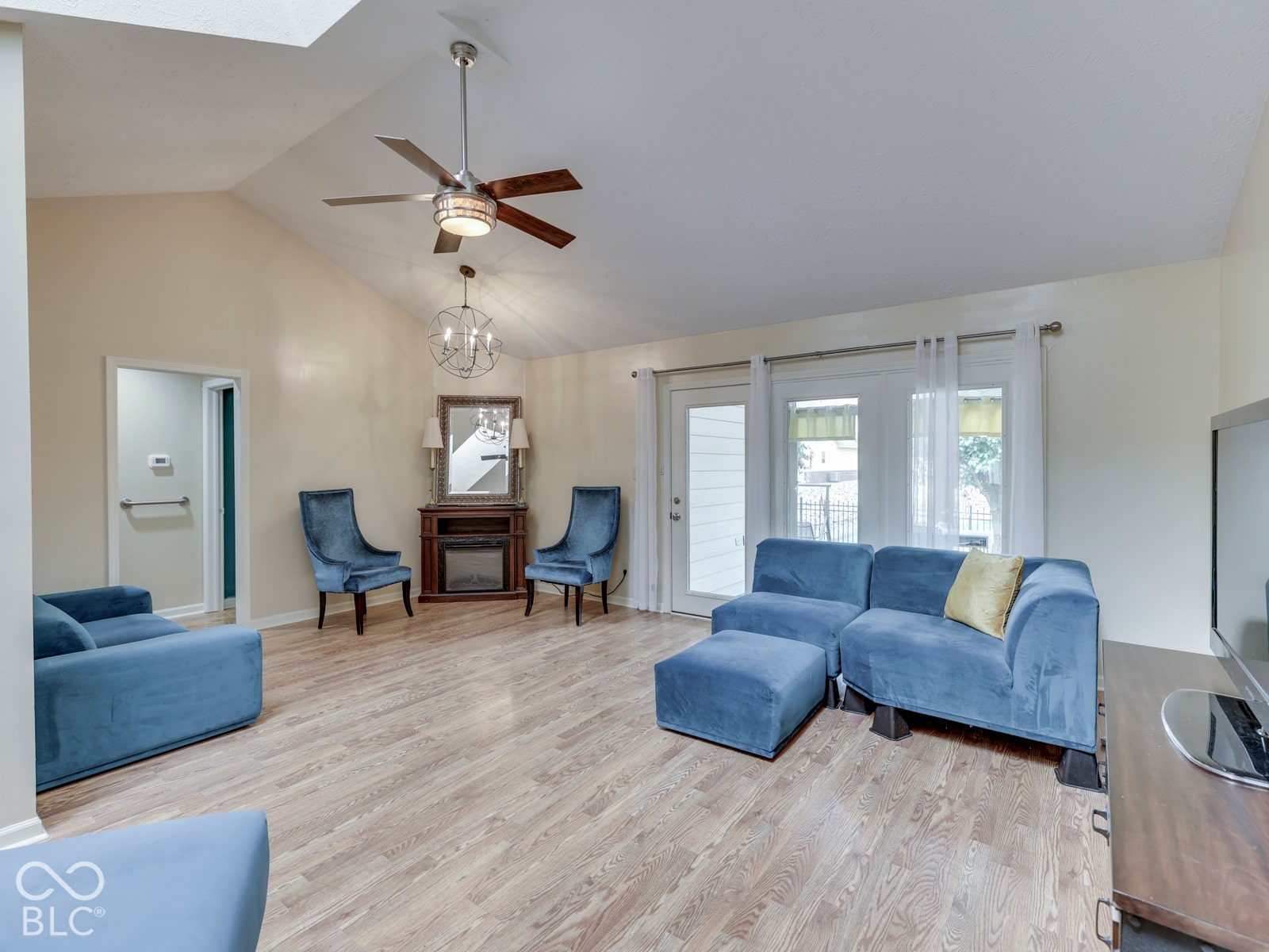770 Ivy Lane, Greenwood, IN 46143 Vaulted ceilings, wood-finish flooring, built-in corner fireplace, ceiling fan with light fixture, and glass-paneled exterior door
