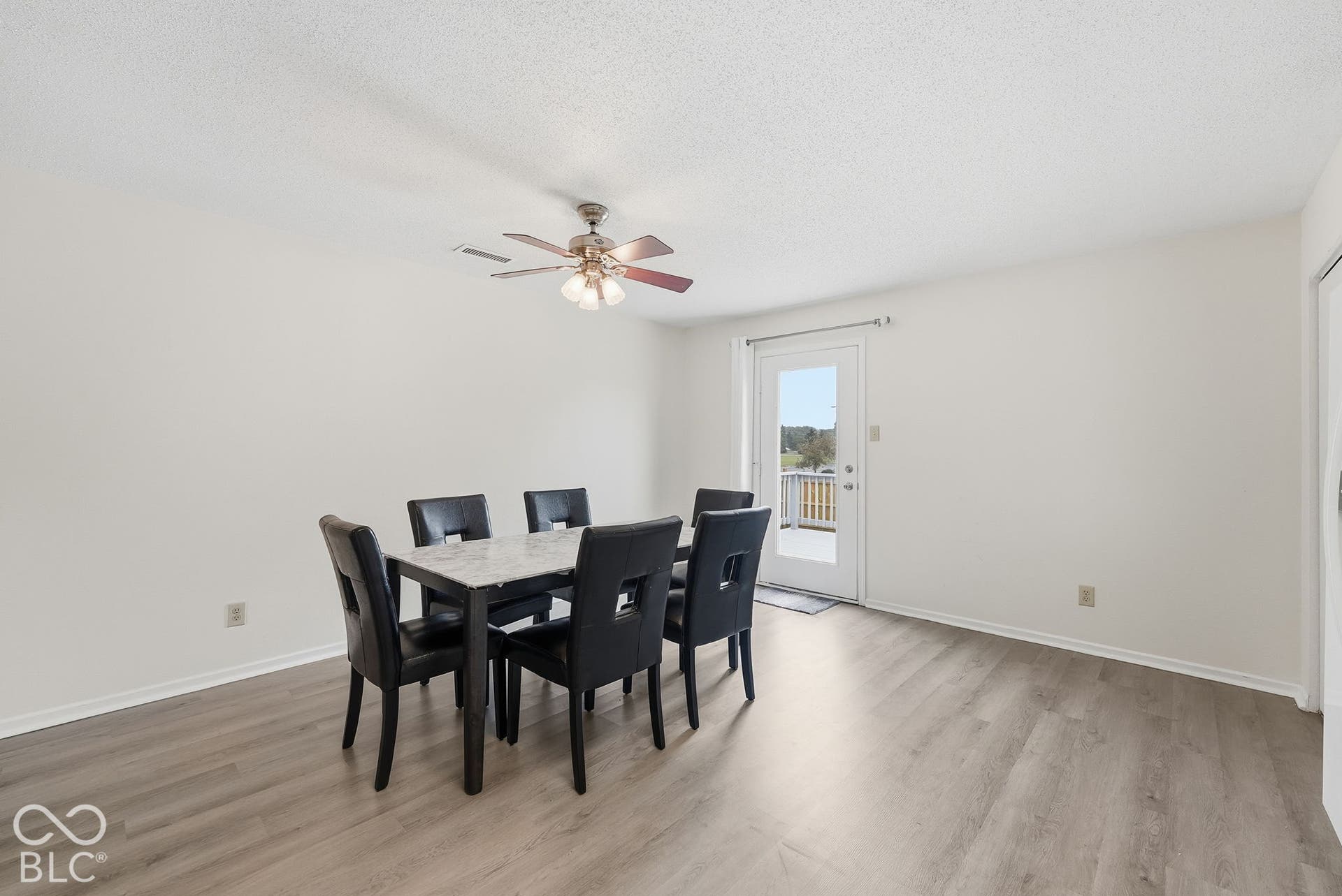 Wood-finish flooring, ceiling fan with integrated lighting, and full-glass exterior door