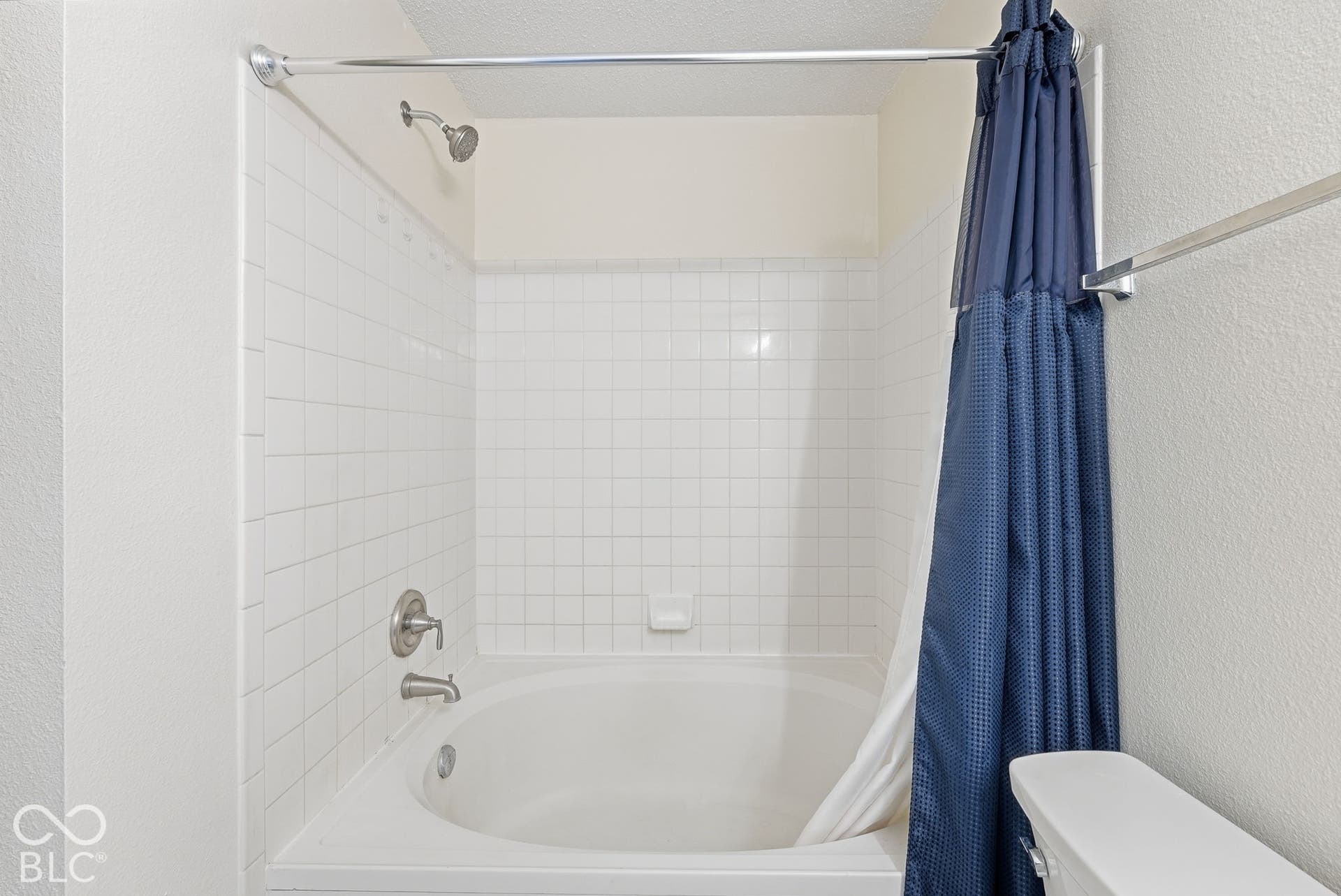 Built-in soaking tub with a tiled surround, chrome shower hardware, and a single-handle mixing valve