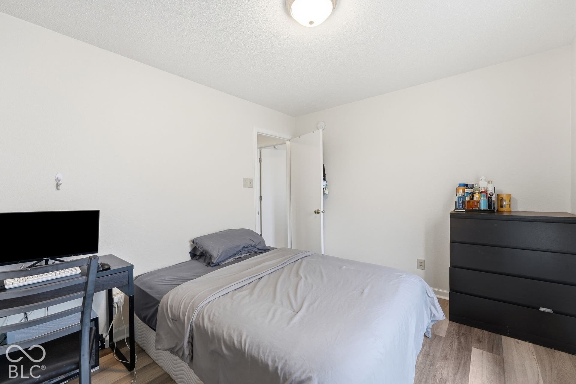 Neutral-toned walls, wood-finish flooring, and a flush-mount ceiling light fixture