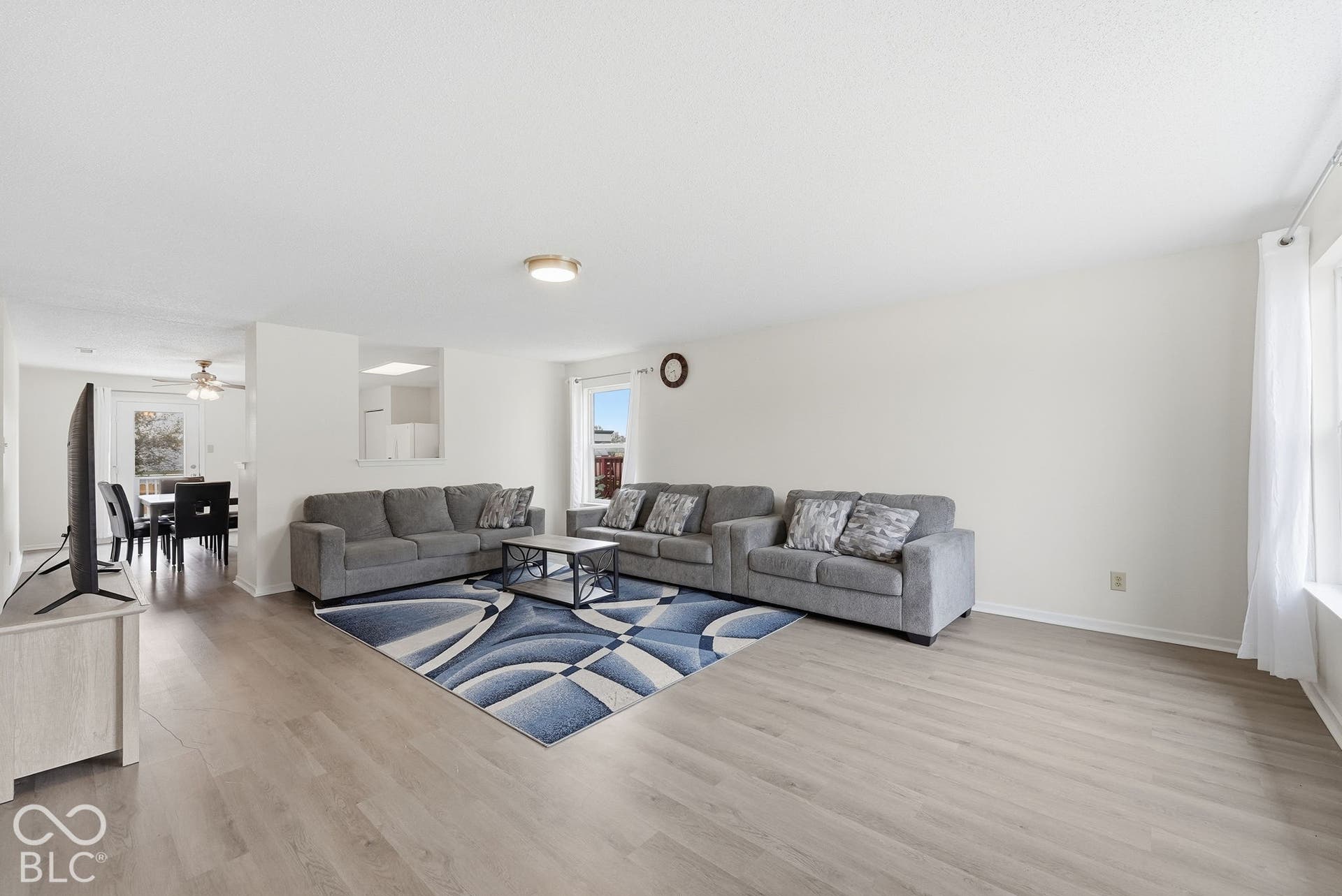 Neutral-toned interior space featuring light wood-finish flooring, crisp white walls, and a recessed pass-through opening