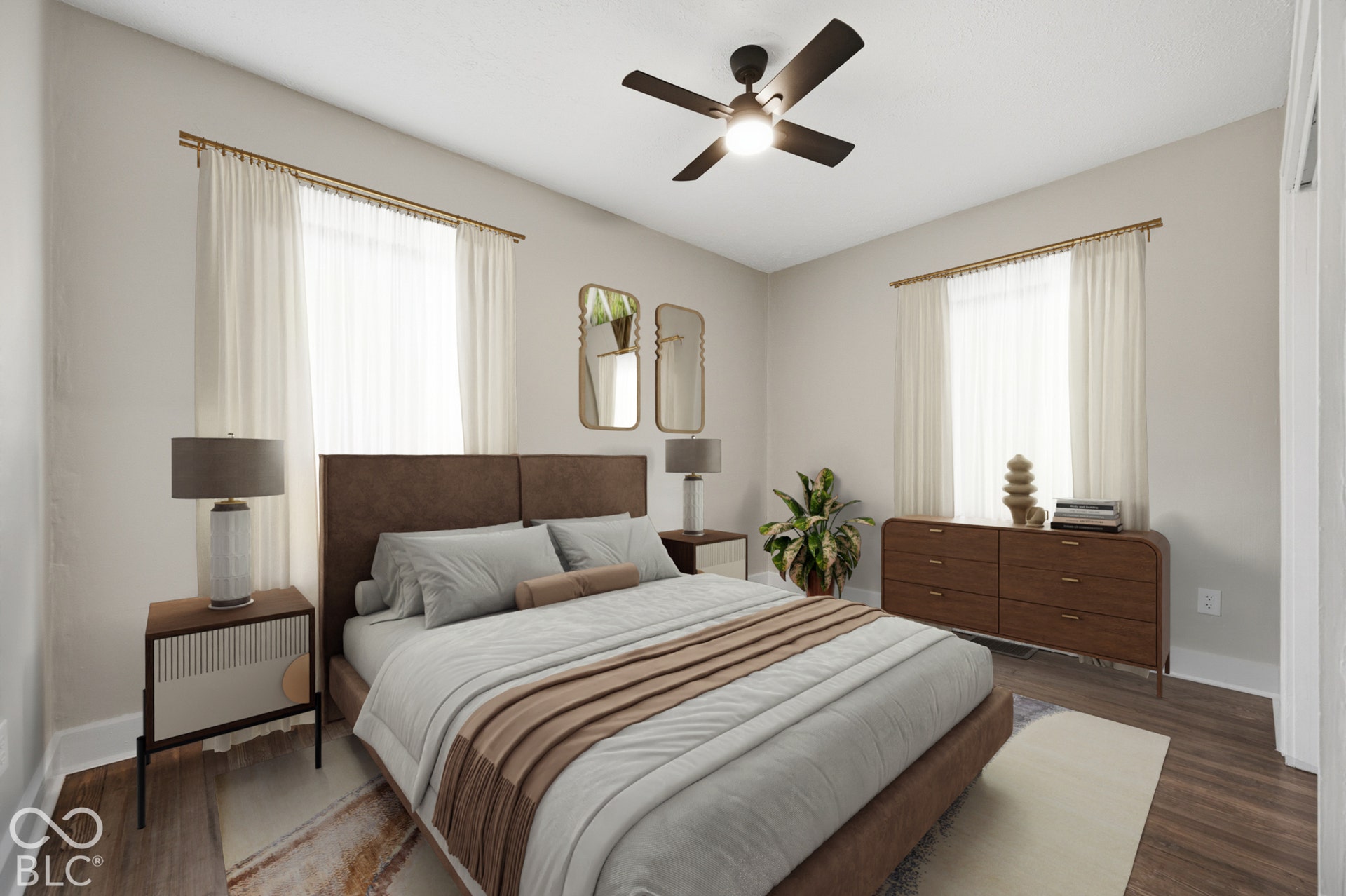 Neutral-toned interior featuring wood-finish flooring, dual windows with mounted drapery hardware, and a ceiling-mounted light fixture with an integrated fan