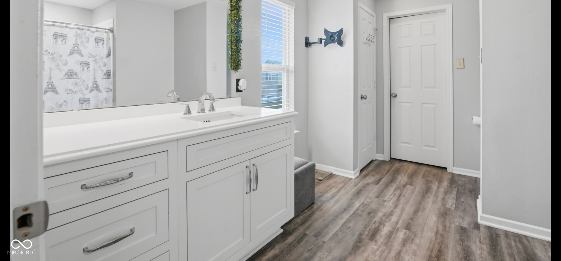 Bathroom vanity featuring a white countertop, undermount sink, and chrome faucet