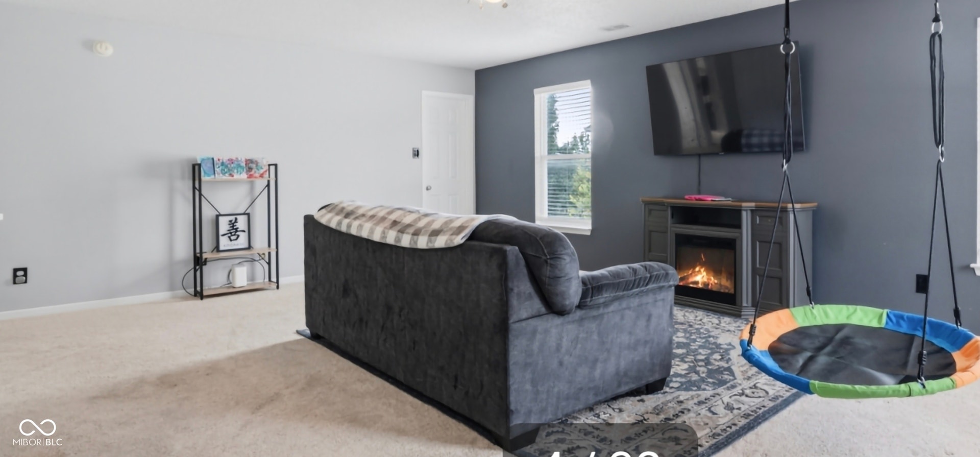 Open-concept room featuring light-toned carpeting and a contrasting accent wall