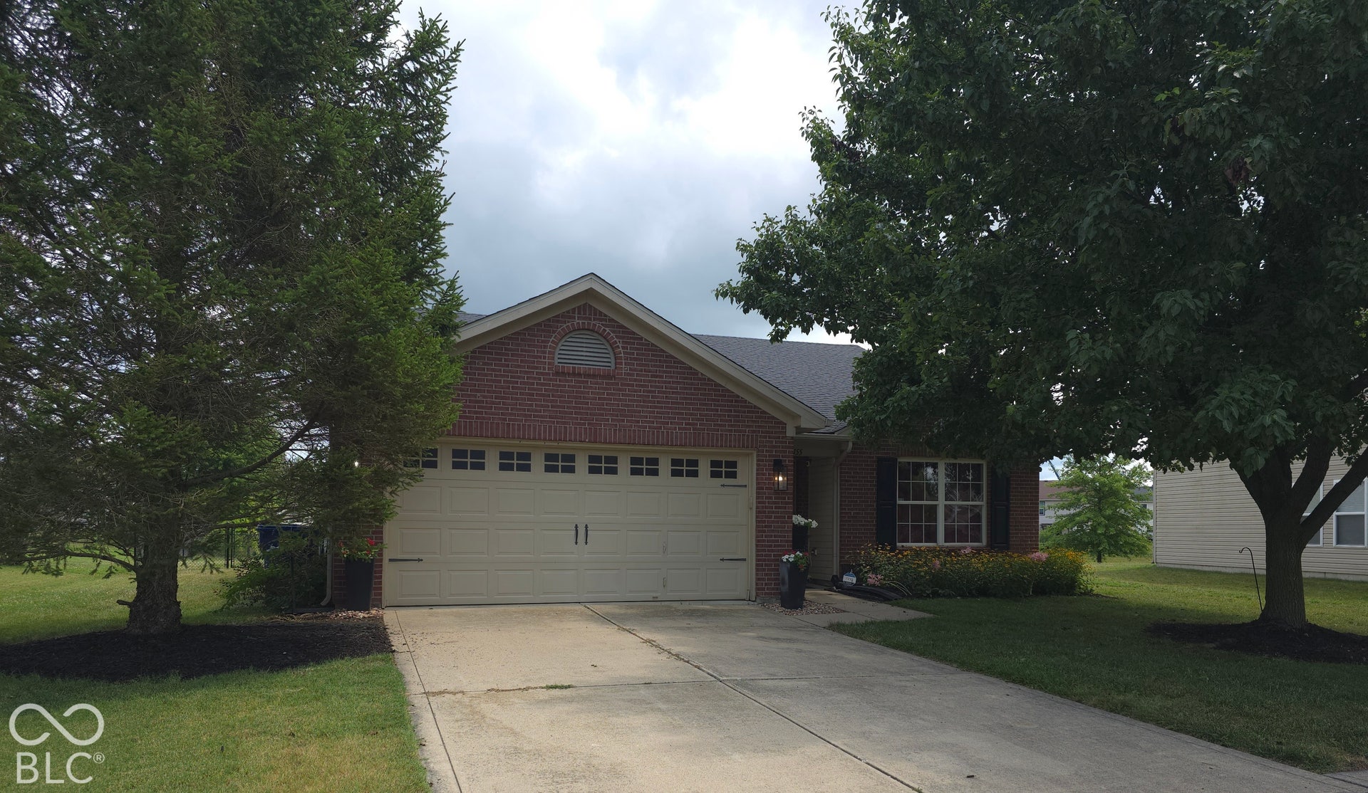 7155 N Lyndhurst Crossing, McCordsville, IN 46055 Brick exterior featuring a gabled roofline, an arched gable vent, and a multi-car garage with transom window detailing